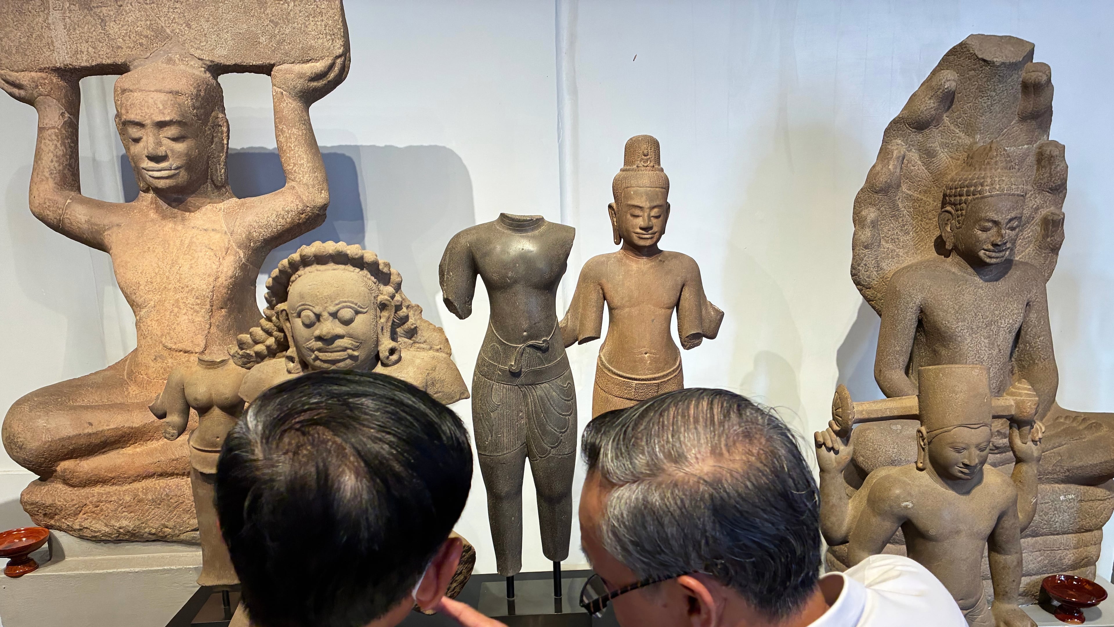 Cambodian officials look at Khmer cultural artifacts that were returned to the country, at the National Museum, in Phnom Penh, Friday, Feb. 27, 2026. (AP Photo/Sopheng Cheang)