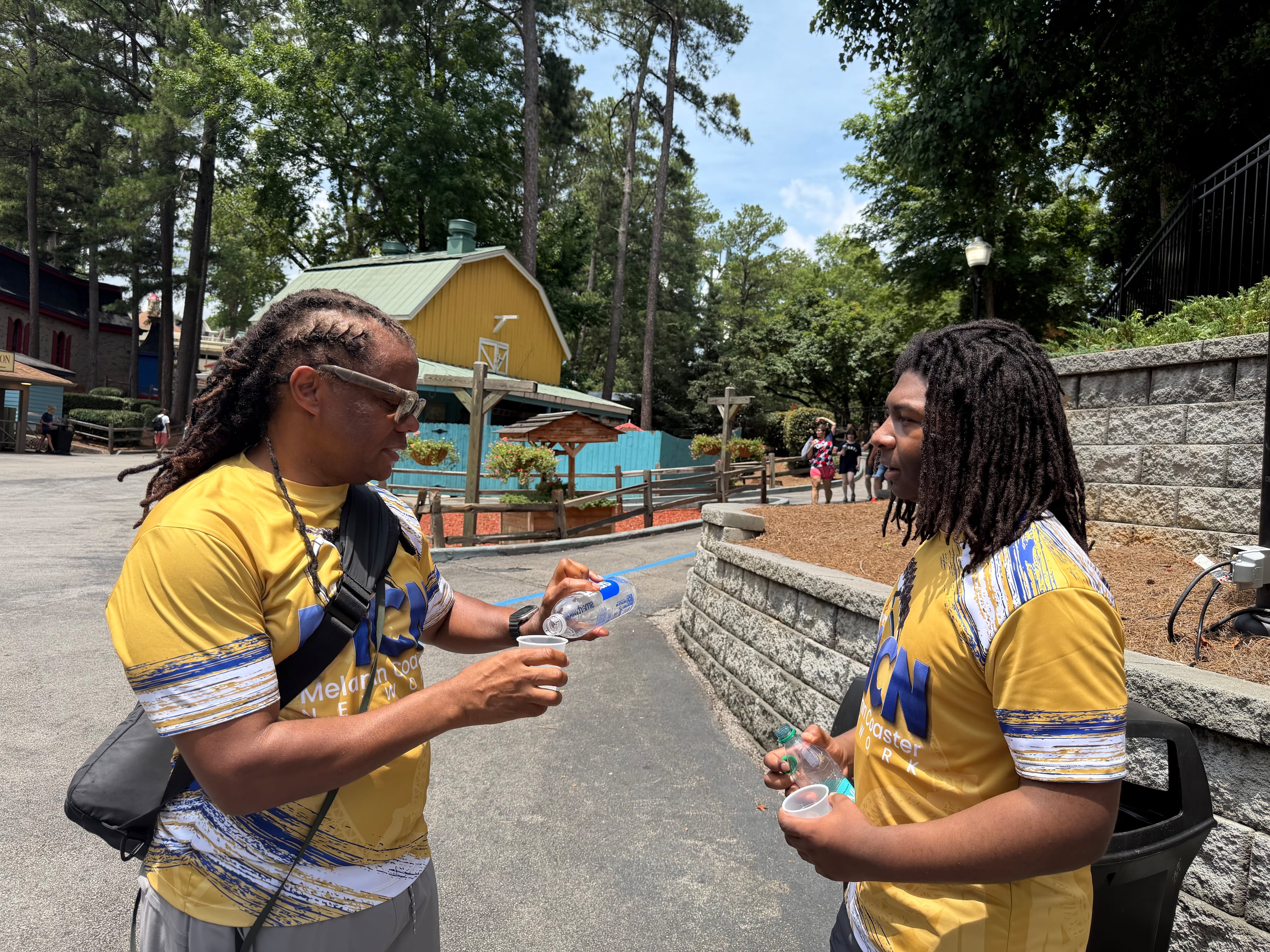 Roller coaster enthusiasts Lonnell Williams (left) and John Green of Atlanta cool off with sips of water while discussing what's next on their itinerary during a recent visit to Six Flags Over Georgia. (Photo courtesy of Jon Waterhouse)