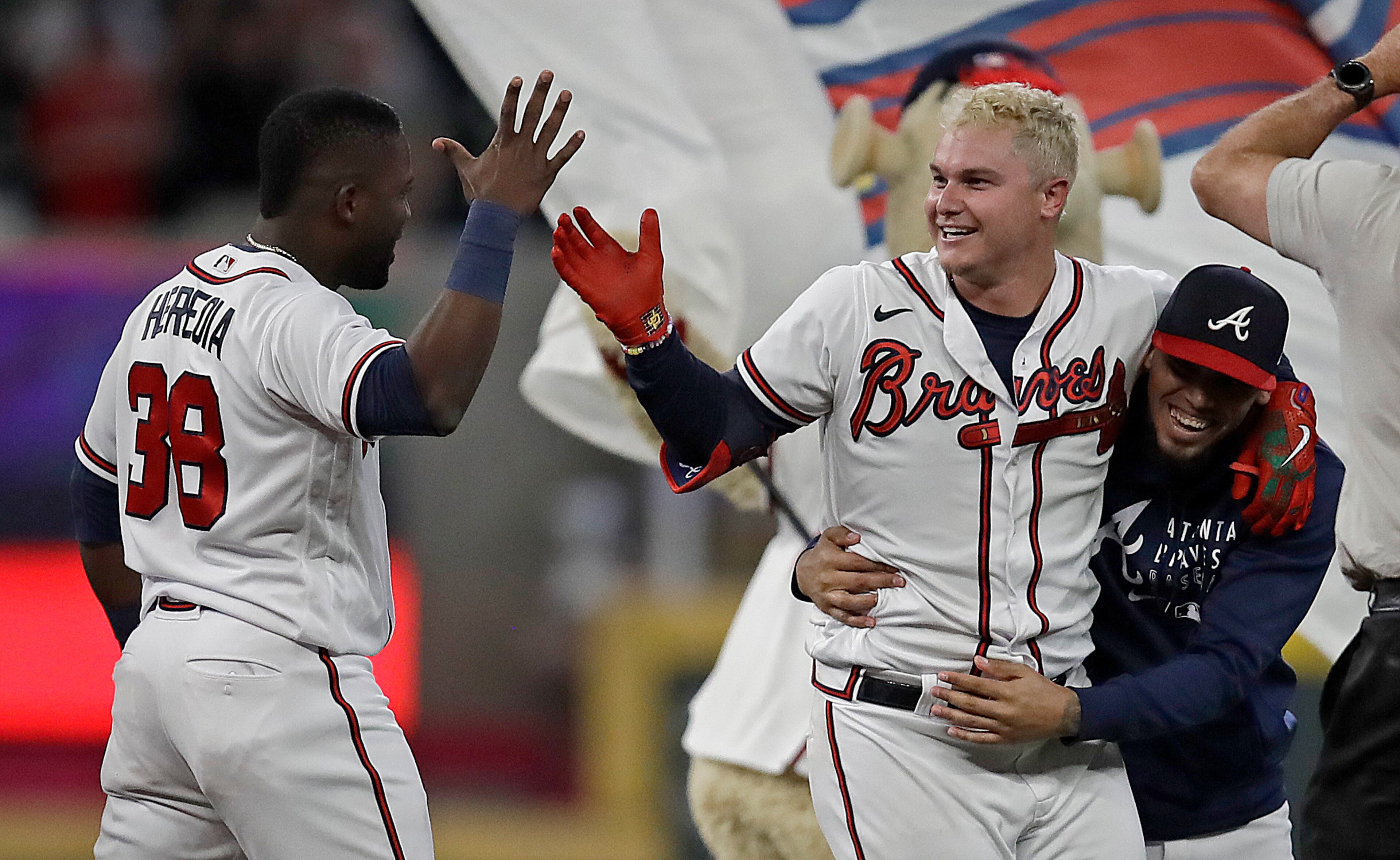 Atlanta Braves' Joc Pederson, center, celebrates with Guillermo Heredia (38) after making the game winning hit against the Washington Nationals in the tenth inning of a baseball game Thursday, Sept. 9, 2021, in Atlanta. (AP Photo/Ben Margot)
