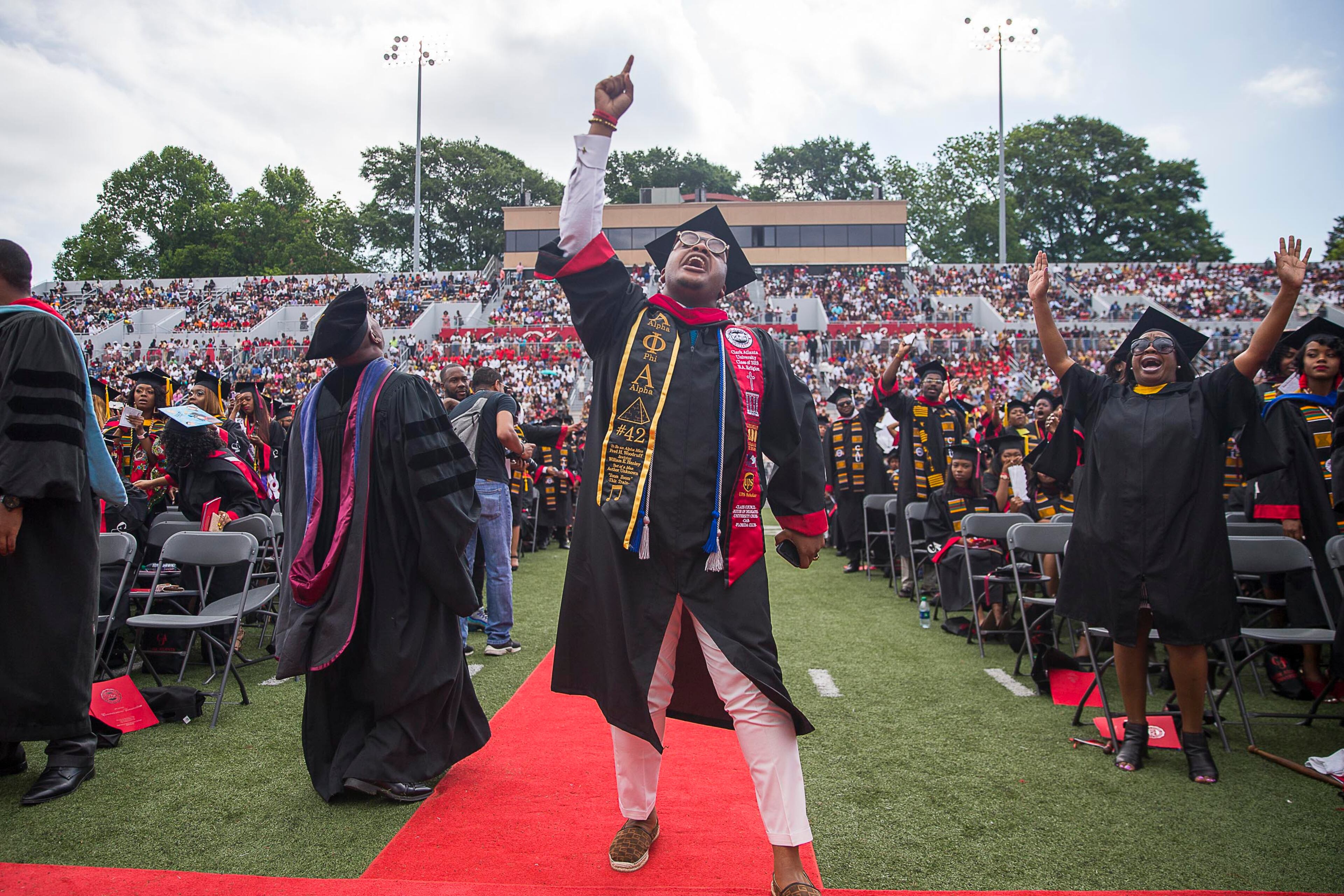 5/20/2019 -- Atlanta, Georgia -- Clark Atlanta University graduate Le'Zaire Reese (center) becomes emotional as a rendition the gospel song, "God is," is performed by The Clark Atlanta University Choirs during the 30th annual commencement ceremony at Panther Stadium in Atlanta, Monday, May 20, 2019. (Alyssa Pointer/alyssa.pointer@ajc.com)