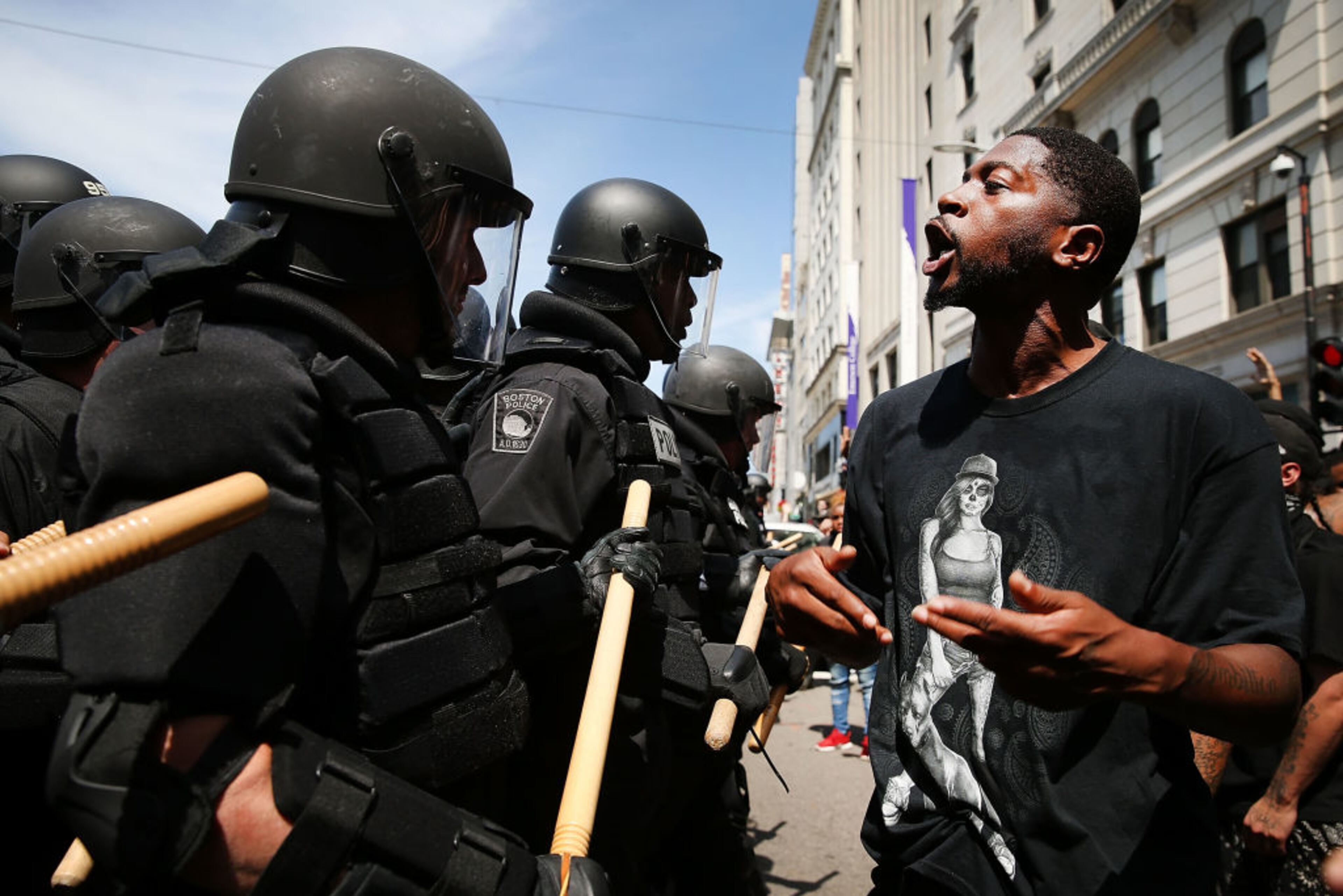 BOSTON, MA - AUGUST 19: Protesters face off with riot police escorting conservative activists following a march in Boston against a planned 'Free Speech Rally' just one week after the violent 'Unite the Right' rally in Virginia left one woman dead and dozens more injured on August 19, 2017 in Boston, United States. Although the rally organizers stress that they are not associated with any alt-right or white supremacist groups, the city of Boston and Police Commissioner William Evans are preparing for possible confrontations at the afternoon rally. (Photo by Spencer Platt/Getty Images)