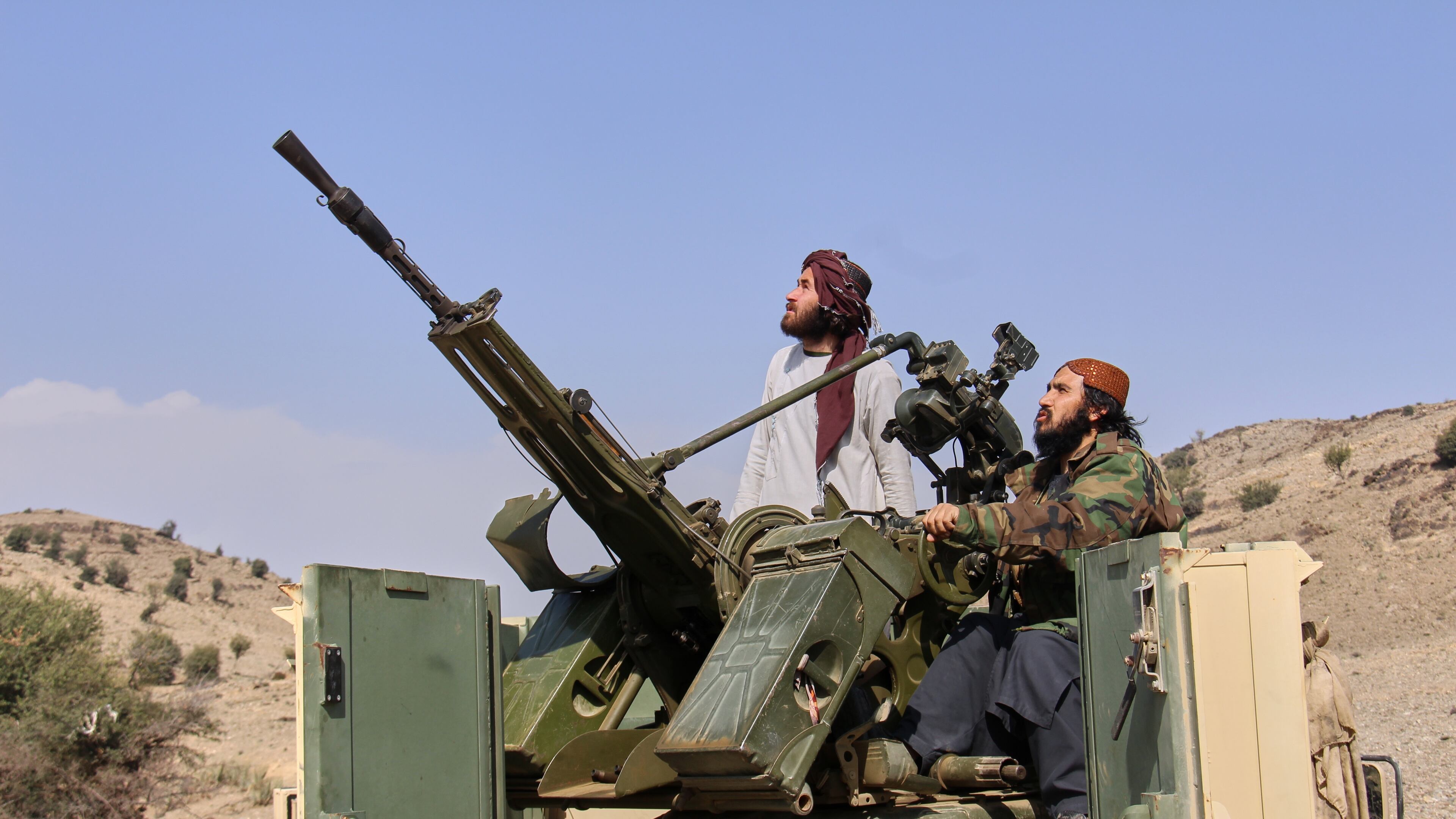 Taliban fighters look up while manning an armed pickup truck at the Afghan side of the Ghulam Khan crossing with Pakistan in Khost province, Afghanistan, Friday, Feb. 27, 2026. (AP Photo/Saifullah Zahir)