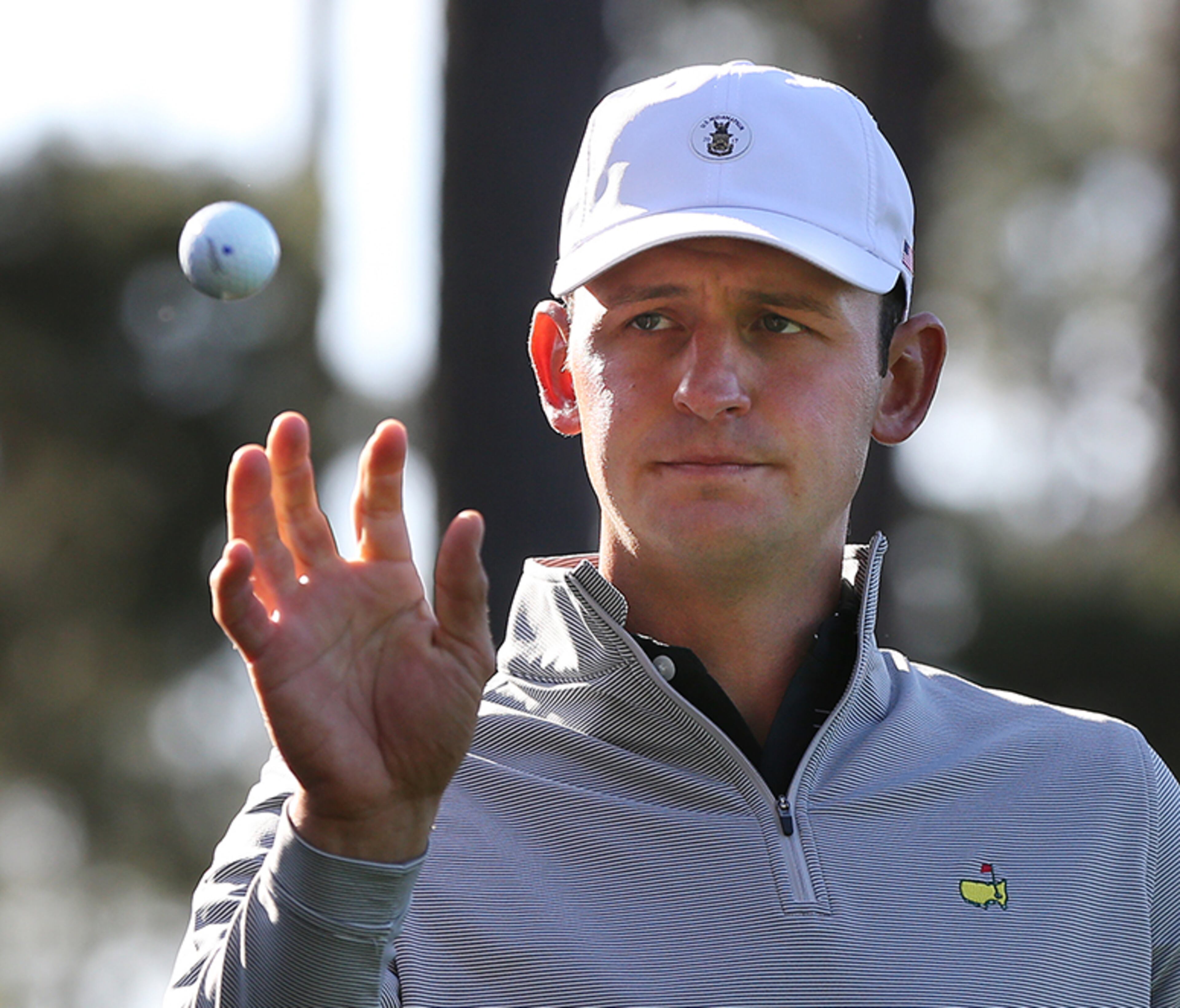 Matt Parziale, the U.S. Mid-Amateur who works as a firefighter in his hometown in Massachusetts, catches a golf ball from his caddy on the fourth tee during his practice round Monday, April 2, 2018, for the Masters at Augusta National Golf Club.
