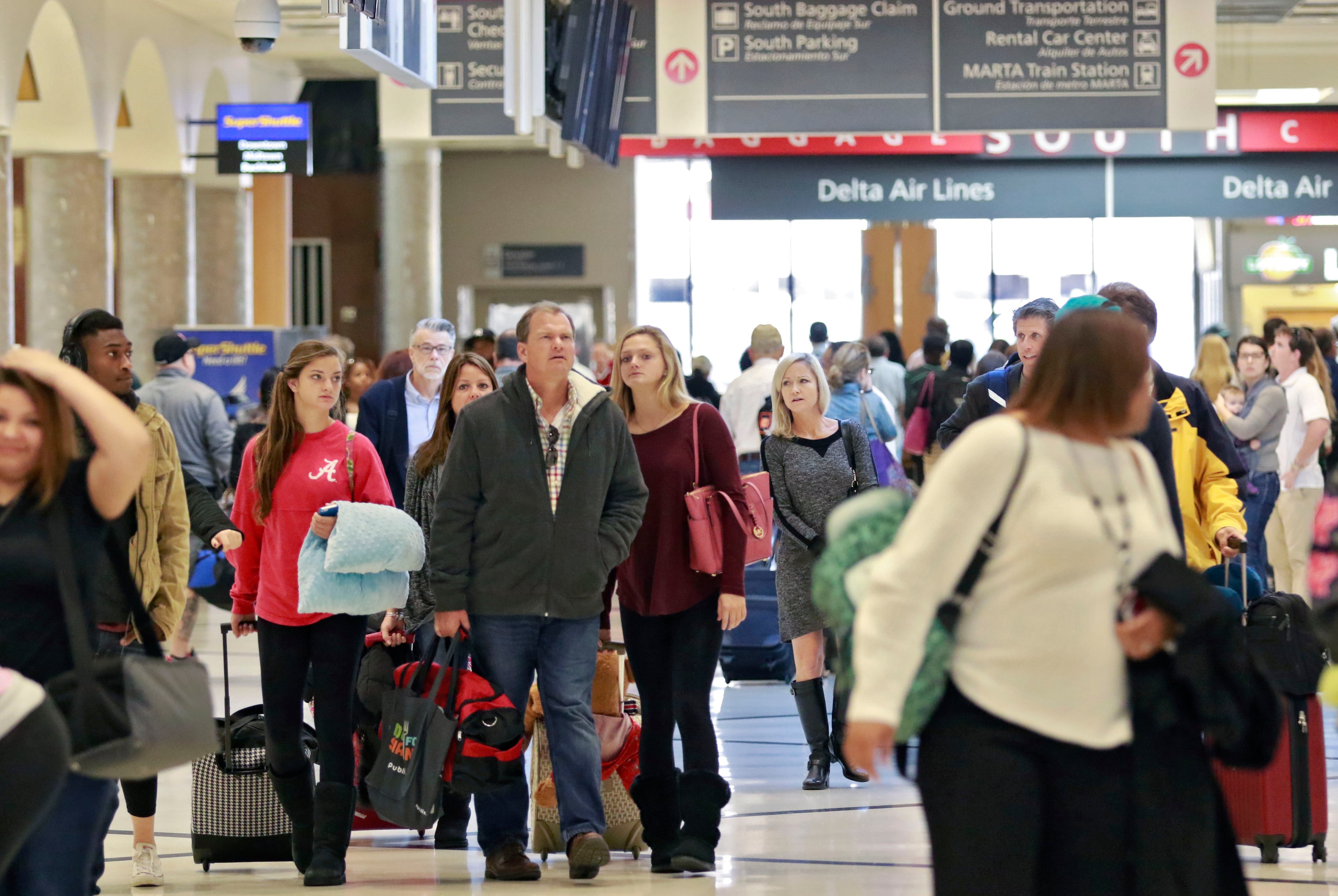 Travelers walk toward baggage claim at the airport. Record crowds are expected along with long lines and delays at Hartsfield-Jackson Atlanta International Airport, this holiday season which is forecasting some of the biggest increases in traffic it has seen in years. BOB ANDRES / BANDRES@AJC.COM