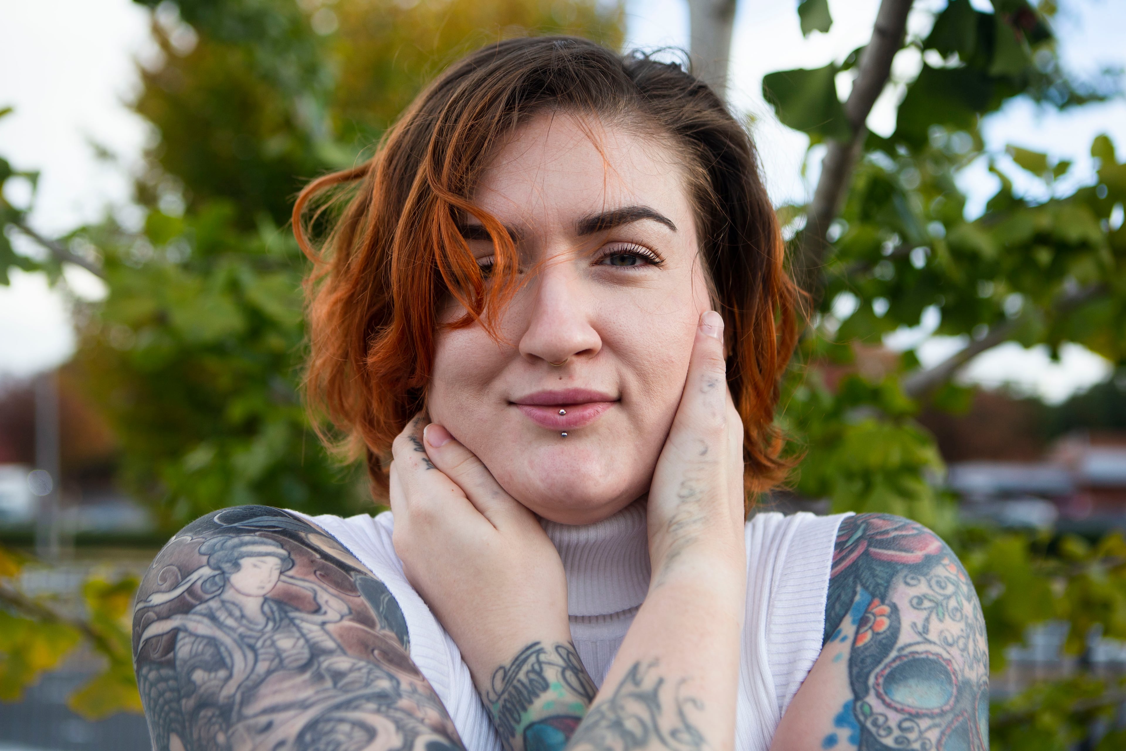 Melissa Walsh poses in Kennesaw for a photo with her tattoos, many of which she wants to keep. But Walsh is in the process of removing two of her tattoos, one on her hand and wrist that says "just survive" and another on her back right shoulder. CHRISTINA MATACOTTA FOR THE ATLANTA JOURNAL-CONSTITUTION.