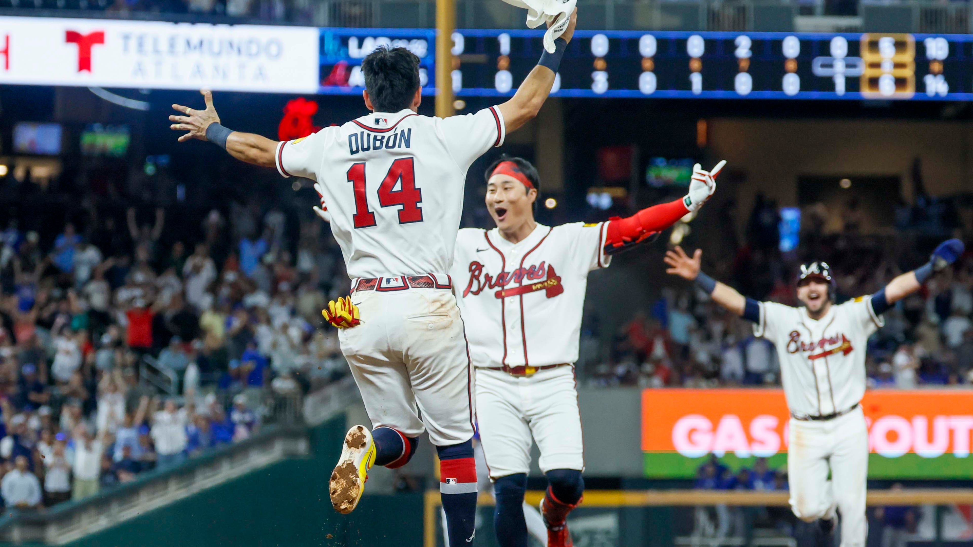 Atlanta Braves left fielder Mauricio Dubón (left) runs to celebrate with teammate Ha-Seong Kim after Kim hit a walk-off single in the ninth inning against the Los Angeles Dodgers at Truist Park in Atlanta on Wednesday, Aug. 26, 2026. The Braves defeated the Dodgers 6-5. (Miguel Martinez/AJC)