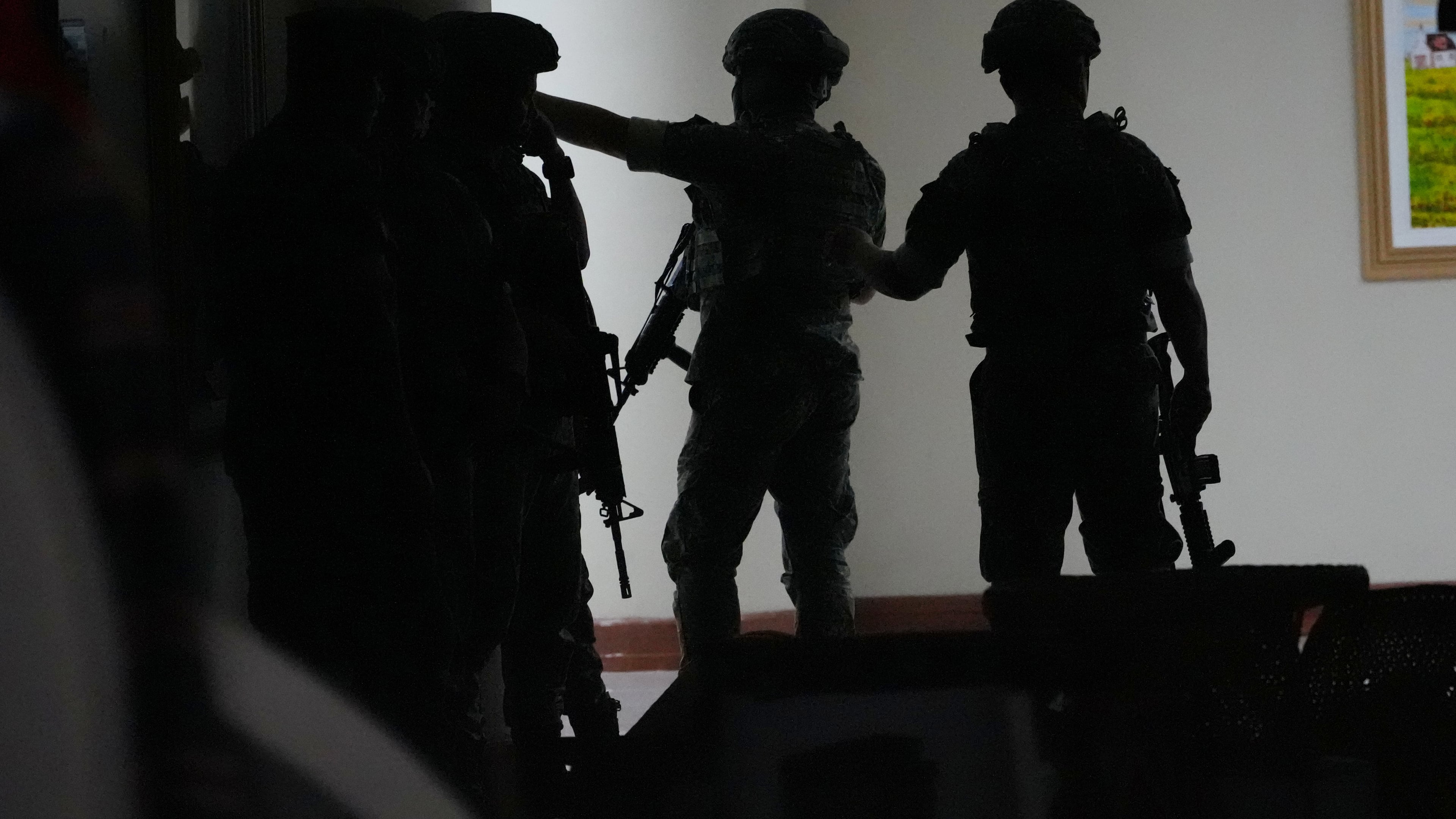 Philippine troopers exchange fire along a hallway at the Philippine Senate in Pasay, Philippines on Wednesday May 13, 2026. (AP Photo/Aaron Favila)