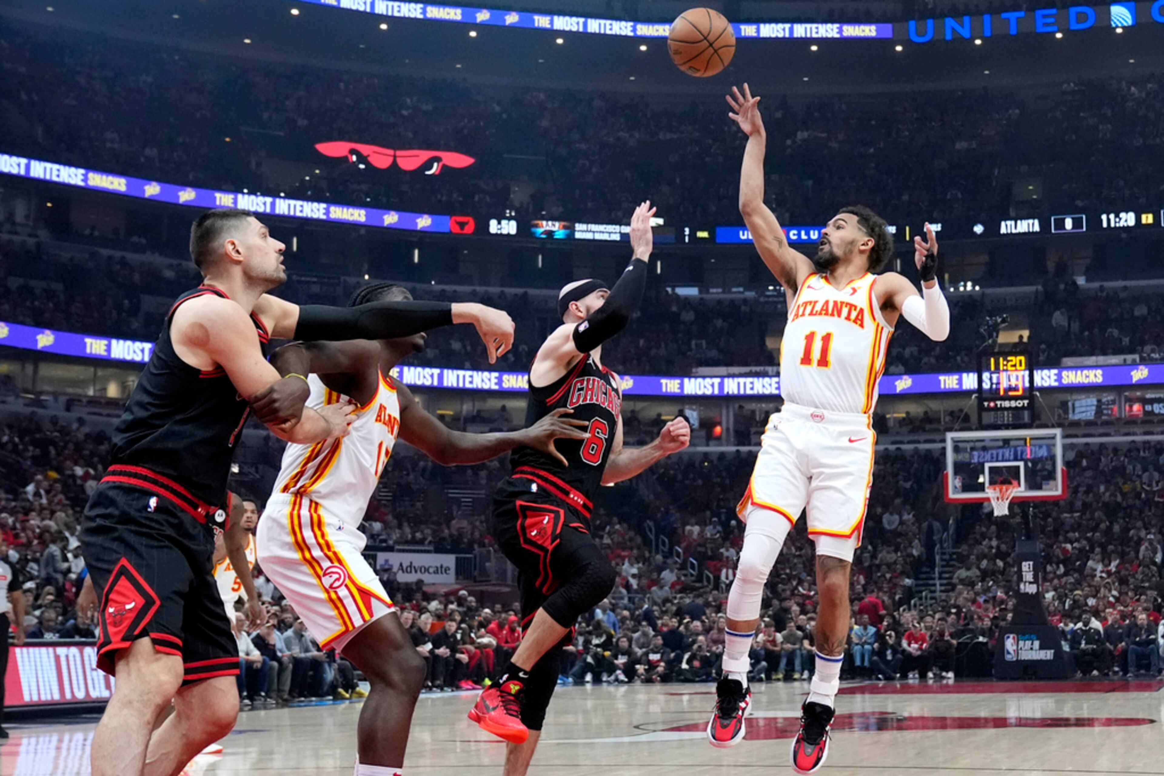 Atlanta Hawks guard Trae Young, right, shoots over Chicago Bulls guard Alex Caruso during the first half of an NBA basketball play-in tournament game in Chicago, Wednesday, April 17, 2024. (AP Photo/Nam Y. Huh)
