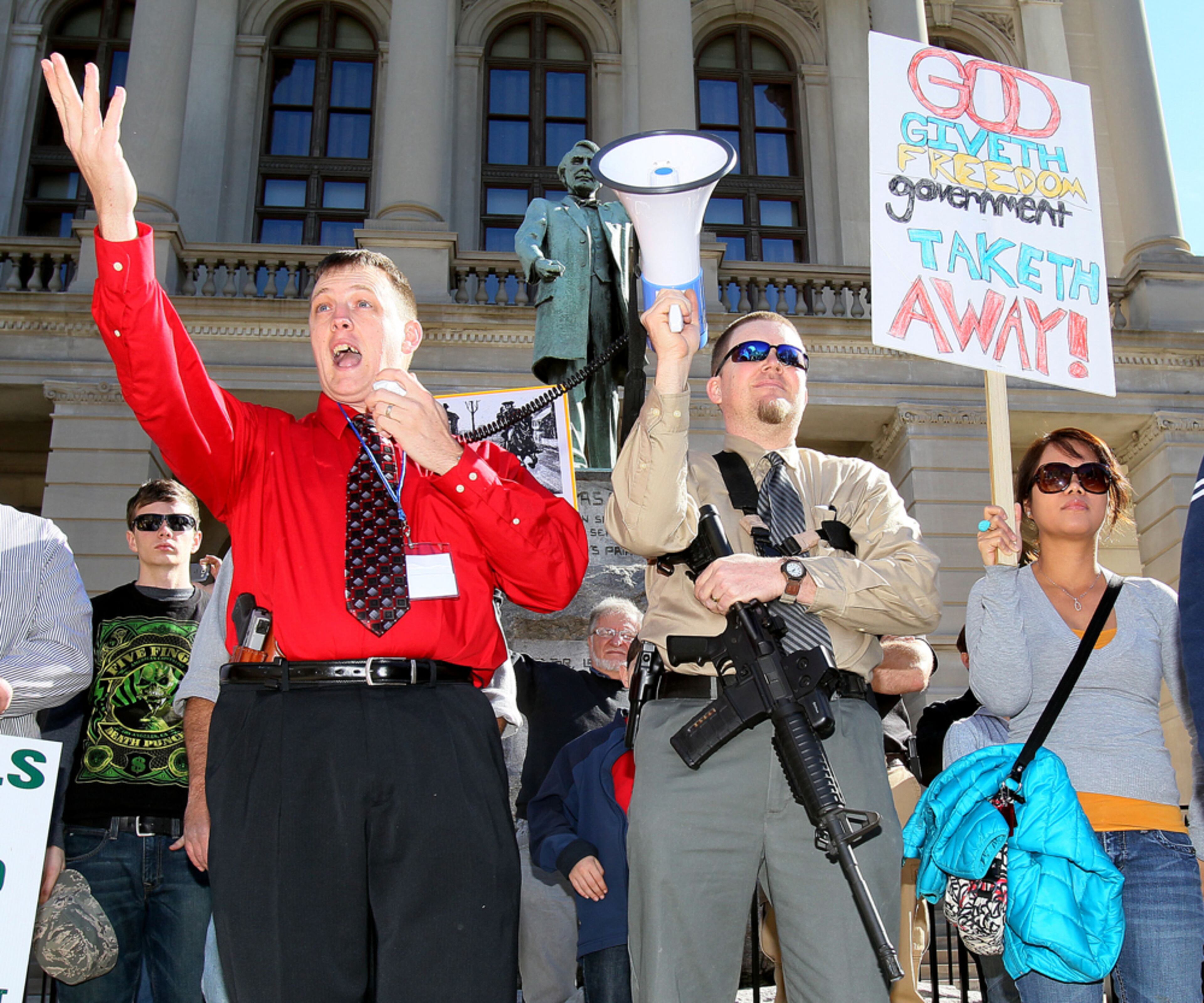 JANUARY 19, 2013-ATLANTA: (left to right)T.J. Hooser made a point as Michael Rugh, carrying his AR15 rifle, held the bullhorn & Luchie Wooten listened as over one hundred protestors attended the "Guns Across American" pro gun rally on the Georgia State Capitol steps on Saturday Jan. 19th, 2013. The crowd waved flags and banners peacefully as several speakers addressed what they consider to be an assault on their second amendment rights to own guns. One speaker, Hugh Scott Shashy, called for President Obama to be impeached. Some protestors openly carried pistols & rifles with legal permits to do so, as Capitol police kept an eye on the crowd. Organizers announced another second amendment rally to take place at the capitol on Feb 8th at 10am. PHIL SKINNER / PSKINNER@AJC.COM Editor's note: CQ
