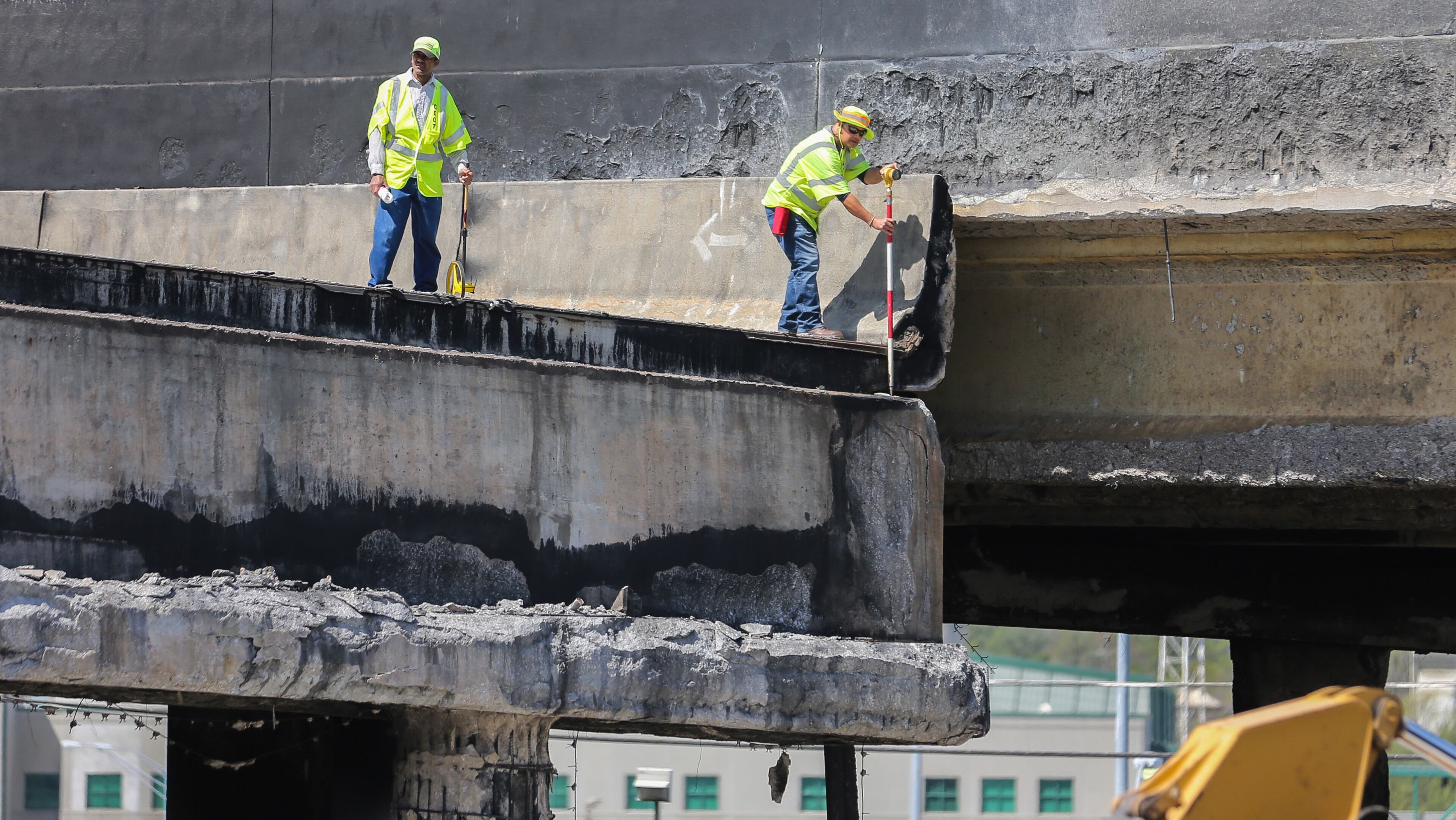 Workers asses damaged area from I-85 collapse Friday, March 31, 2017, in Midtown. The northbound lanes of I-85 fell during Thursday's evening rush hour following a massive fire under the roadway.
