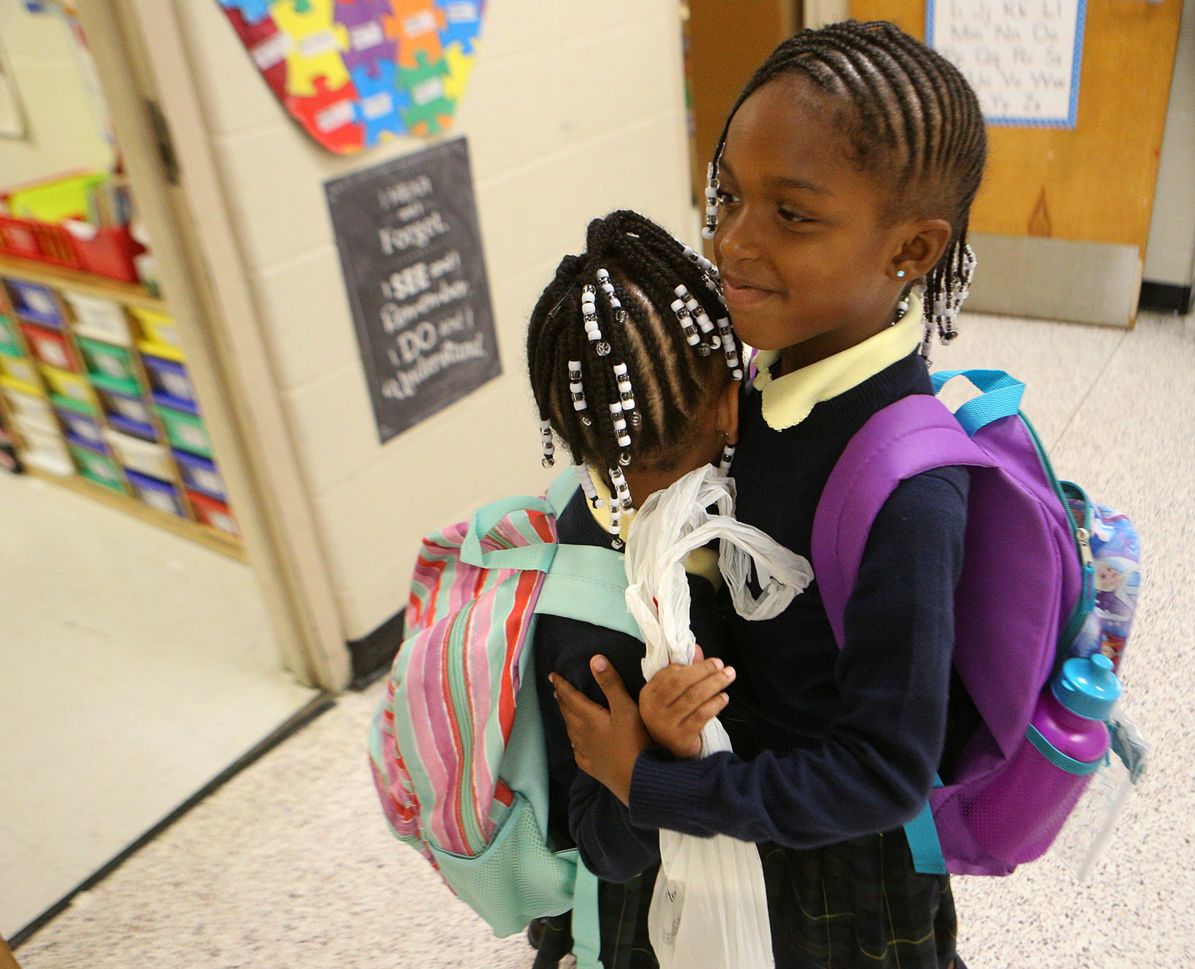 August 7, 2017 Lithonia; âSISTERLY LOVEâ Katelyn Burton, 7, hugs her younger sister Kamryn Howe, 5, goodbye after walking her to her kindergarten class for the first day of school at Edward L Bouie Elementary School after arriving on the bus on Monday, August 7, 2017, in Lithonia. Curtis Compton/ccompton@ajc.com