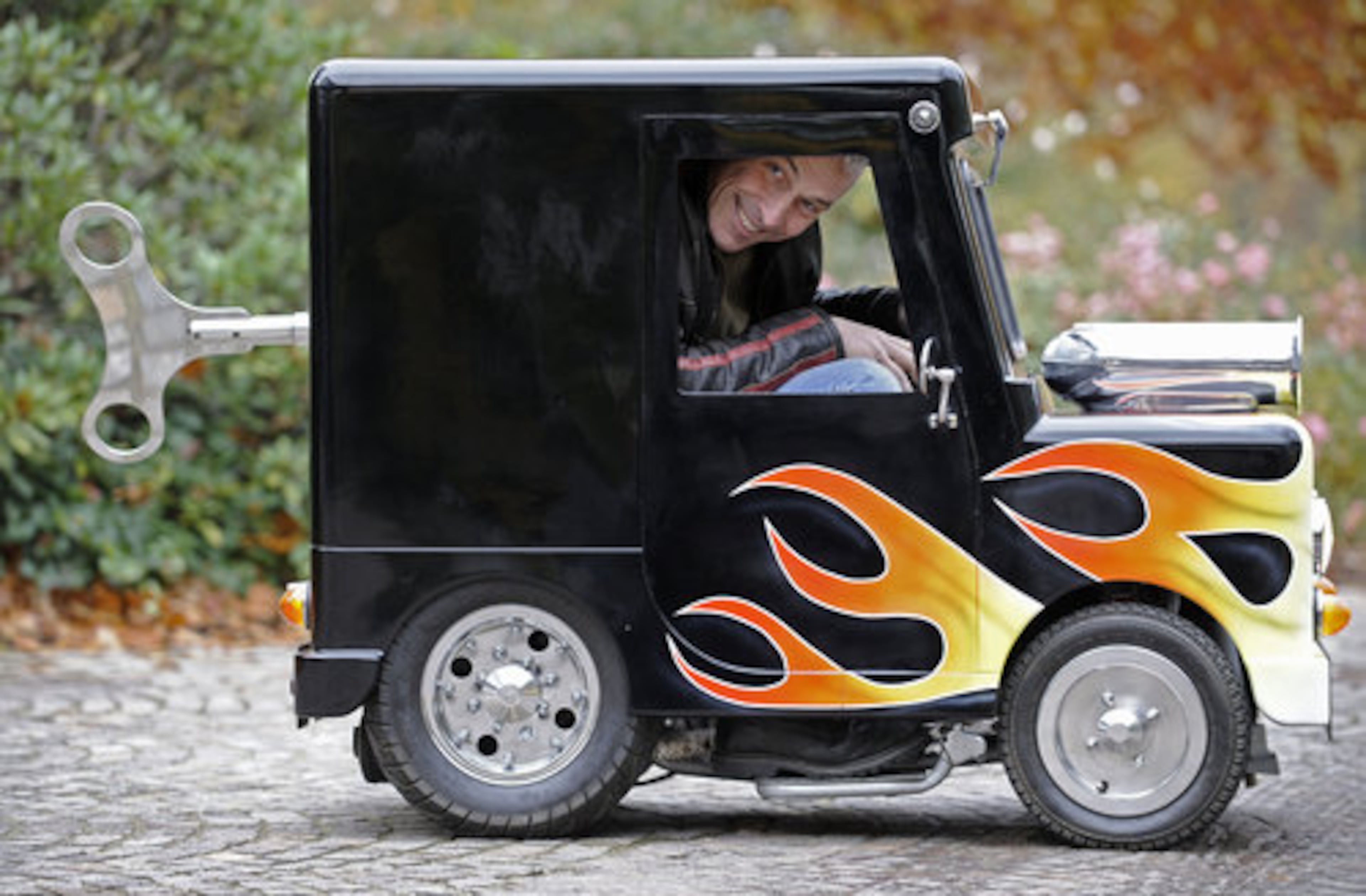 British constructor Perry Watkins sits in his "Wind Up" mini car on a street in Essen, Germany, Monday, Nov. 8, 2010. The car is listed in the Guinness book of records as the world's smallest car with a license to drive on public streets. Just 41 inches high, 51 inches long and only 26 inches wide the mini always finds a parking space. It can drive 60 kph and even has security belts. The car will be shown at the motor show starting Nov. 27 in Essen.