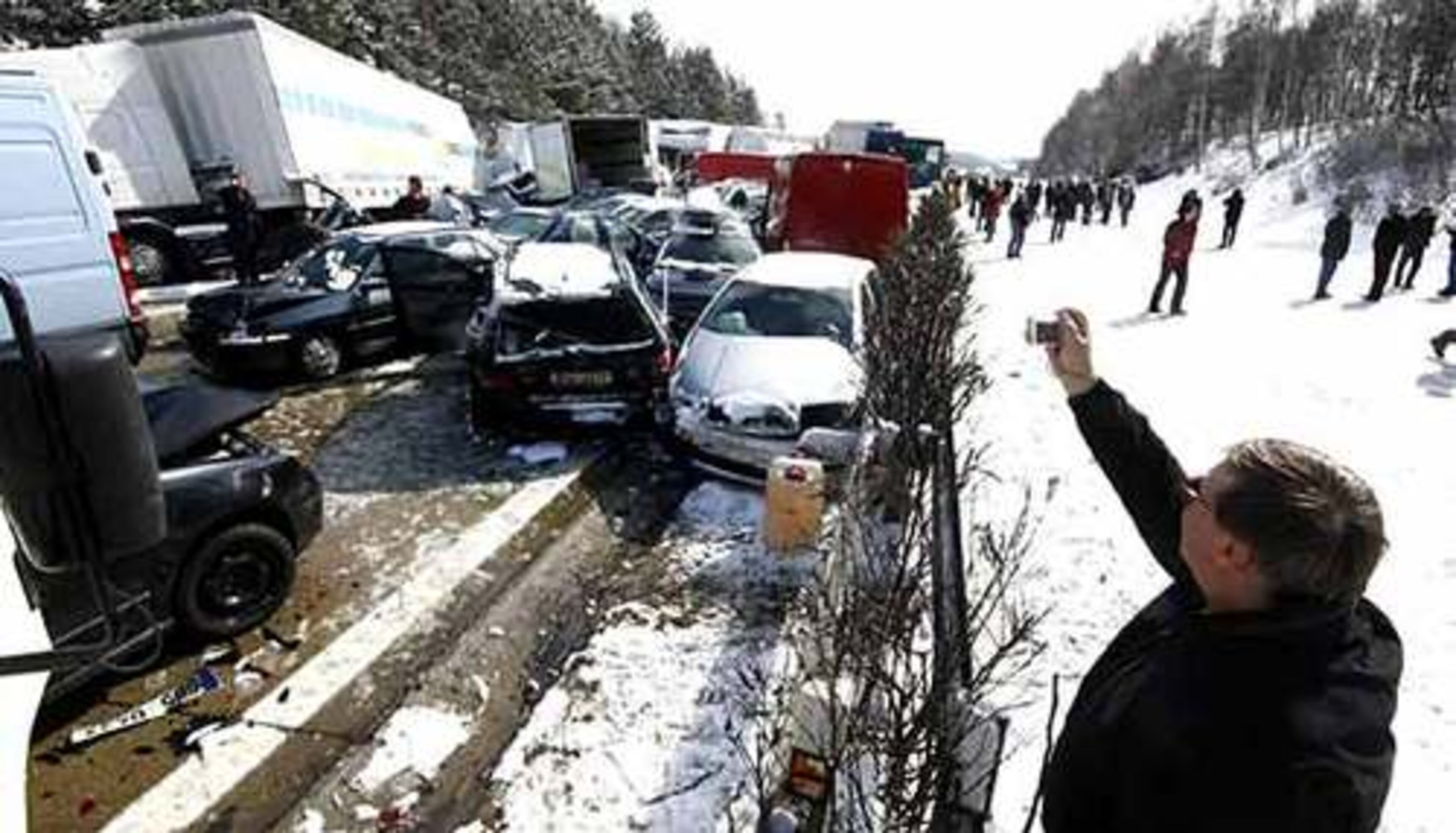A man takes a picture of crashed cars on the Czech D1 motorway between Prague and Brno near Skorkov where tens of vehicles collided in a series of crashes in a snowstorm on Thursday, completely blocking the road. Twenty-six people were injured, including six serious injuries. Officials said 116 vehicles were involved in the collision.