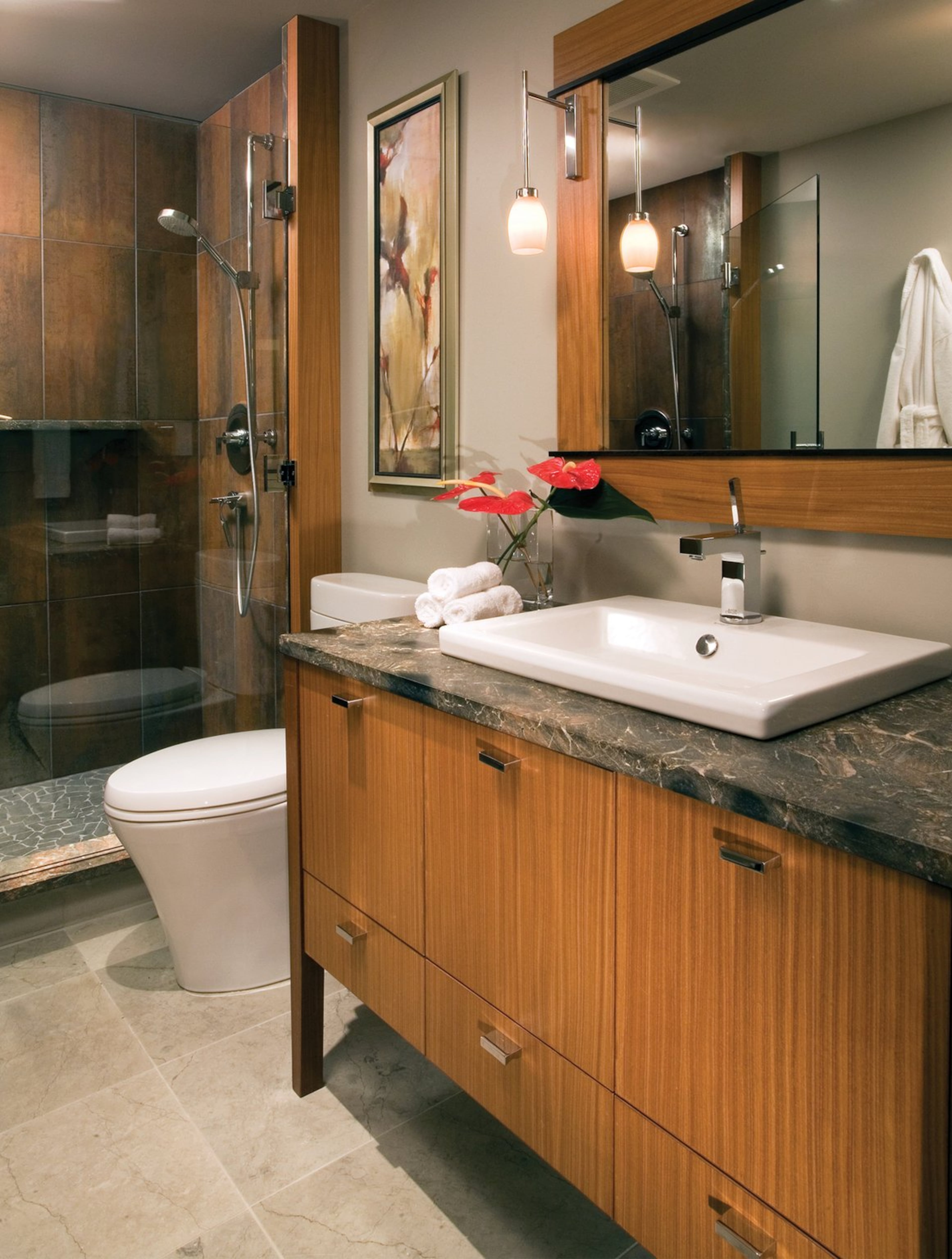 The homeowners, who fell in love with outdoor showers on their travels to Bali and have an Asian-inspired garden, wanted to create a natural transition from their garden to their interior, especially the shower. They used stacked, pebble accent tile, black basalt on the shower floor and other natural stone materials to create the effect.