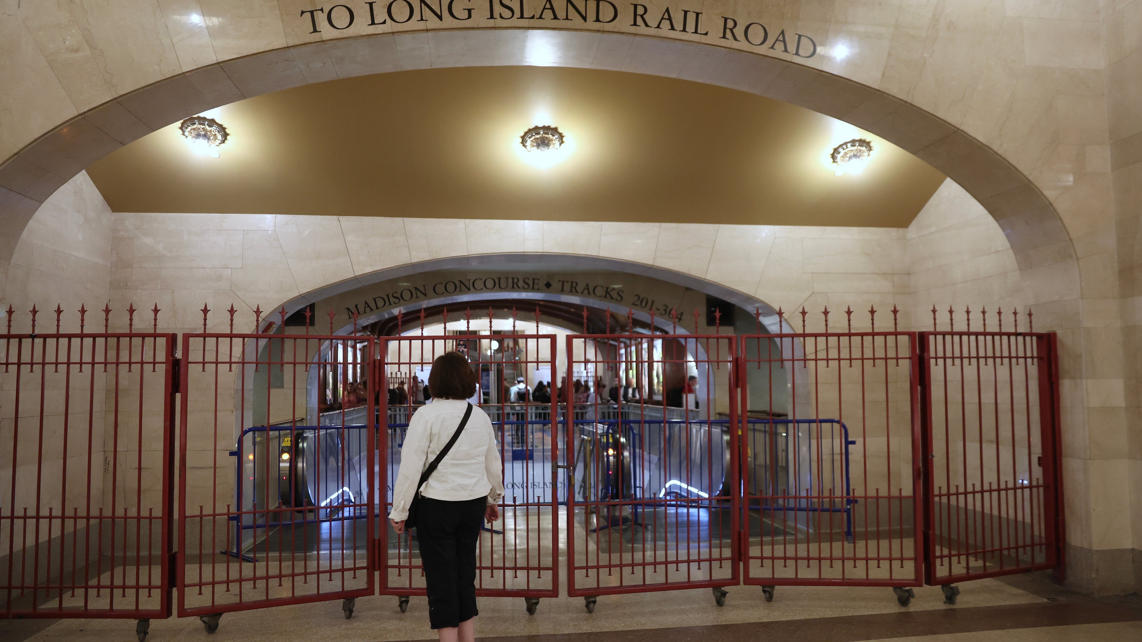 A passenger looks at a closed off entrance to the Long Island Rail Road at Grand Central station, Saturday, May 16, 2026, in New York, on the first day of a strike after five unions representing about half the LIRR's workforce walked off the job. (AP Photo/Heather Khalifa)