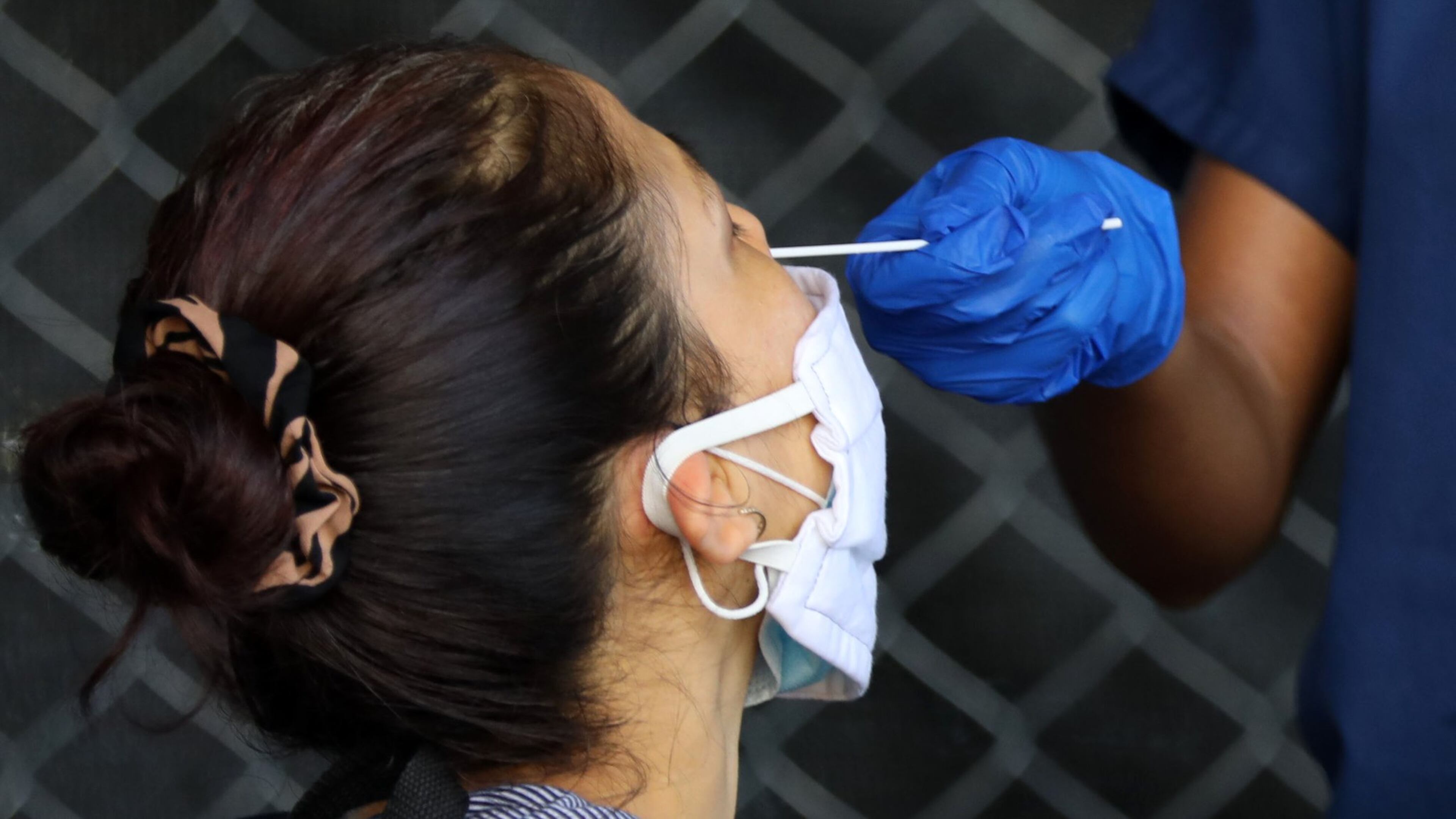 A person gets the swab with the COVID-19 test on her nose during a free test drive on the Good Samaritan Clinic’s parking lot. The Clinic offers free check with the results in 15 minutes on June 23, 2020, in Atlanta. MIGUEL MARTINEZ FOR THE AJC