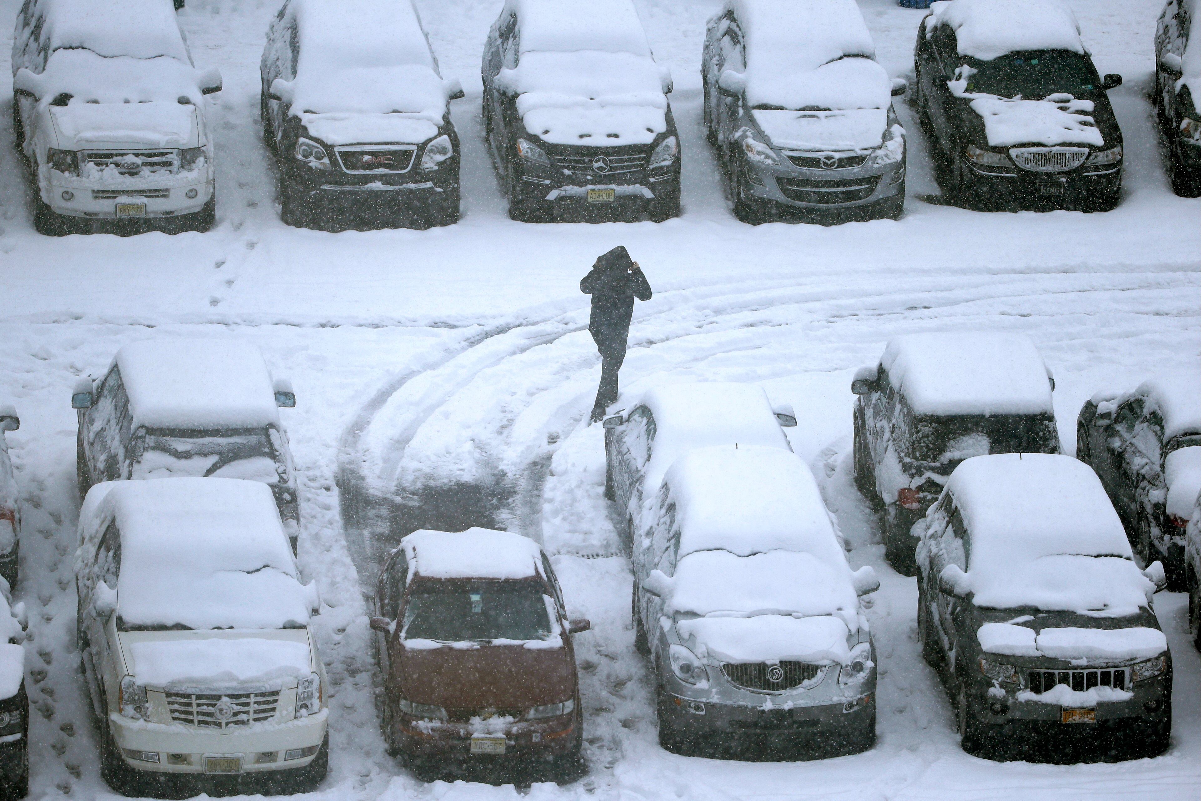 A person walks in a snow-covered parking lot outside Lincoln Financial Field during the second half of an NFL football game between the Philadelphia Eagles and the Detroit Lions, Sunday, Dec. 8, 2013, in Philadelphia.