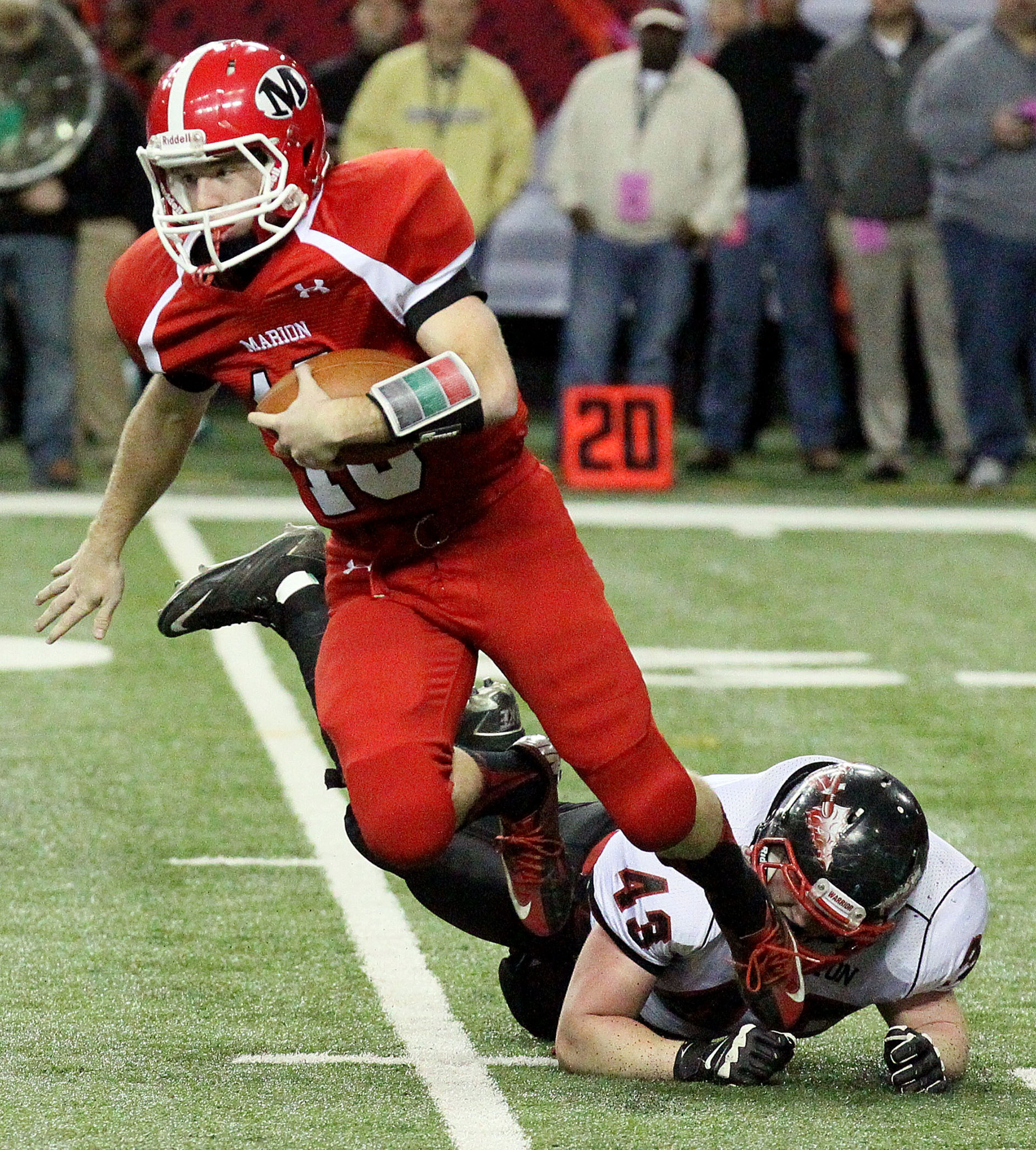 Marion County's (Buena Vista, GA) quarterback #16 Justin Eckert scrambles under pressure from Charlton County's (Folkston) #43 Drake Gillis during their GHSA Class A-Public Football Championship game at the Georgia Dome in Atlanta on Saturday, December 14, 2013.
