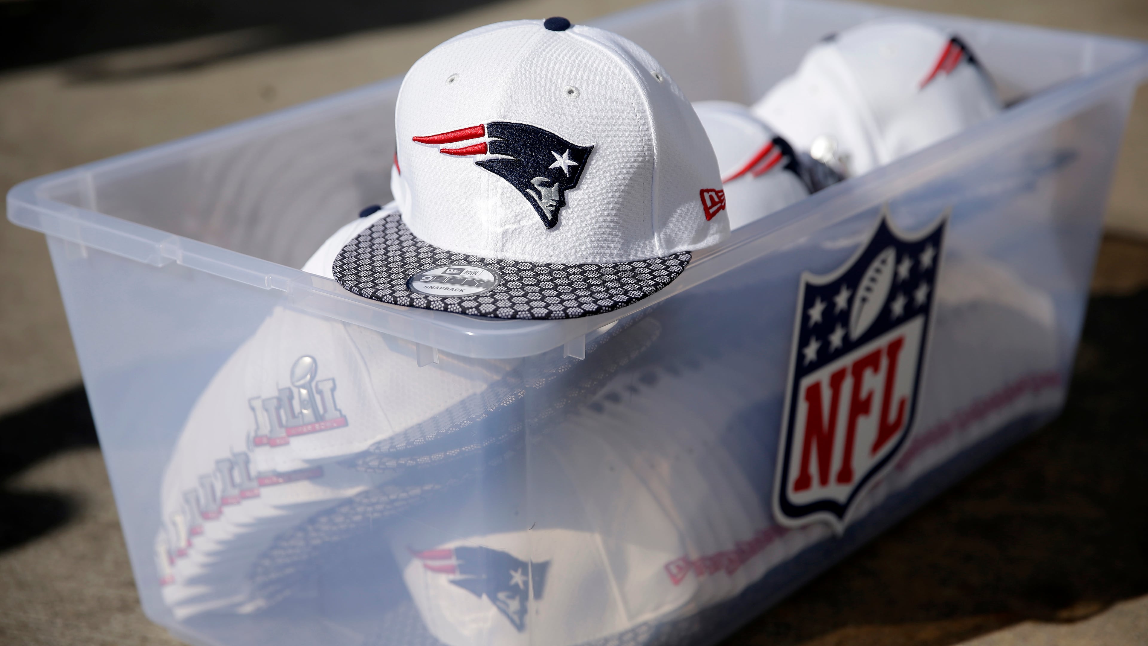 A box of caps to be given to members of the New England Patriots sit on the ground before the team's arrival at George Bush Intercontinental Airport Monday, Jan. 30, 2017, in Houston.