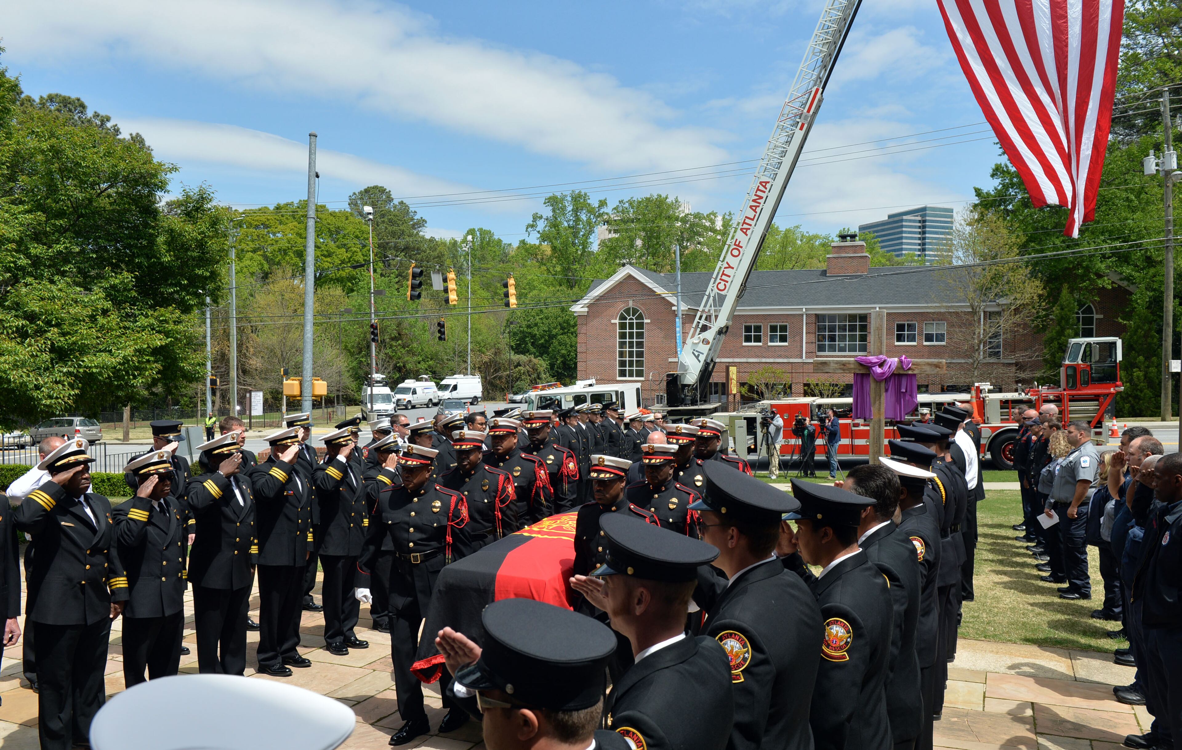 Atlanta Fire Rescue officials and firefighters salute as the casket is brought into the church. They joined with family and friends during the funeral of AFR Sgt. Frank Guinn at Peachtree Road Presbyterian Church, Thursday, April 17, 2014.