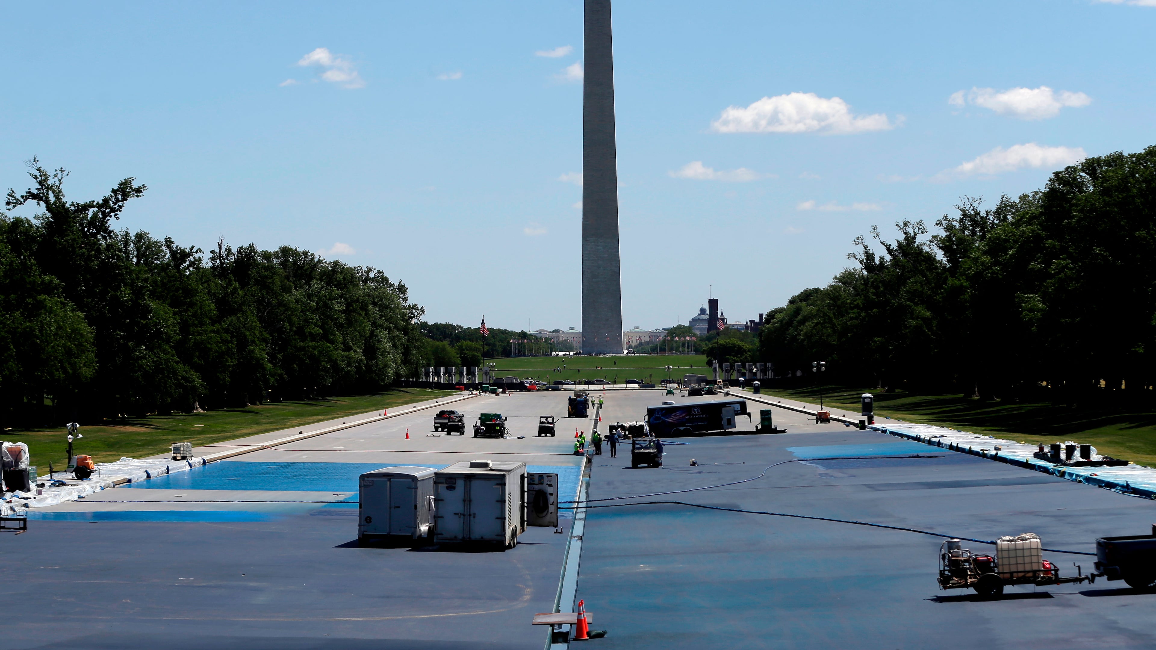 Workers apply a blue protective coating as part of a renovation project to the Lincoln Memorial Reflecting Pool, Friday, May 8, 2026, on the National Mall in Washington. (AP Photo/Rahmat Gul)