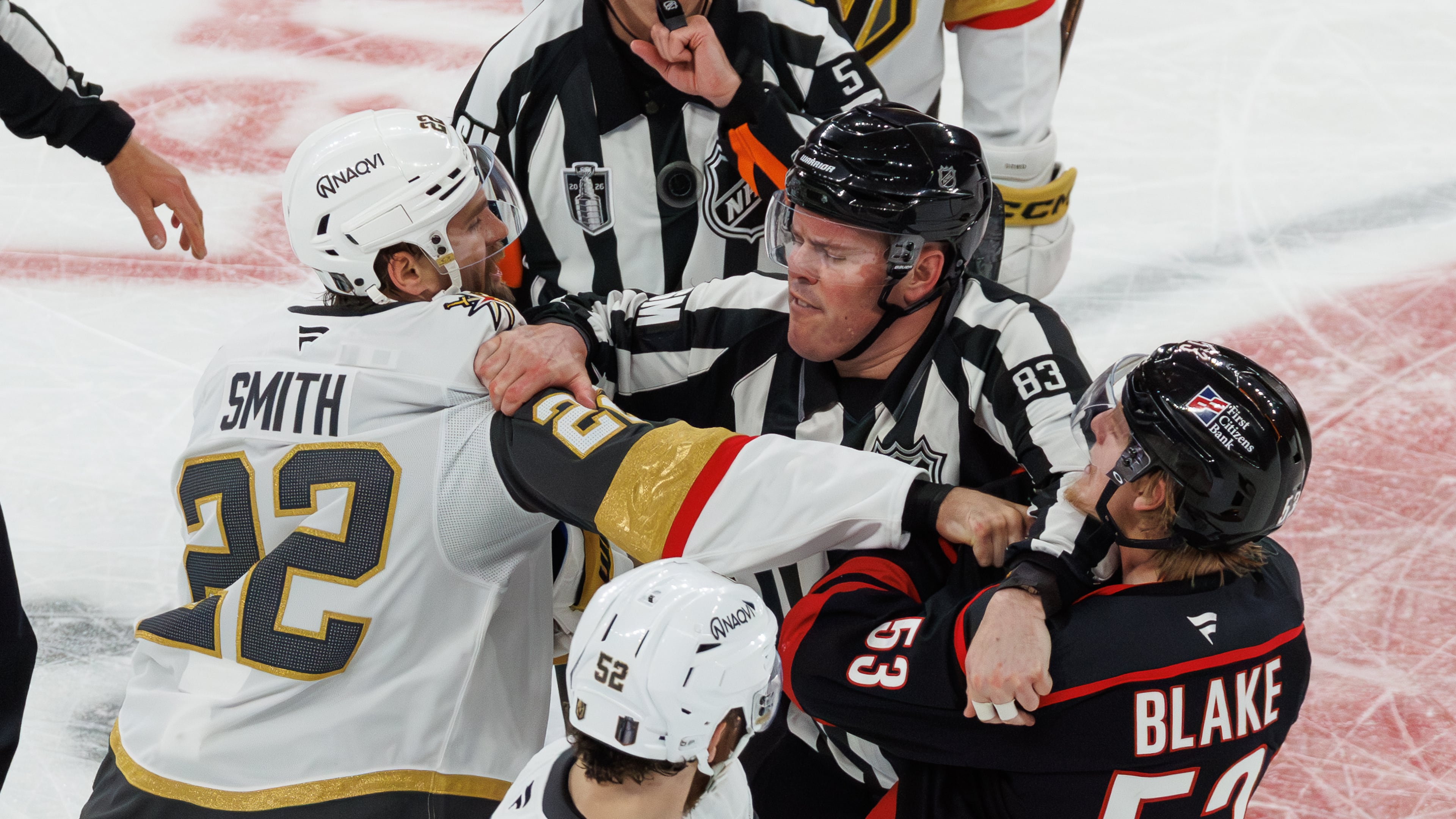 Vegas Golden Knights' Cole Smith (22) and Carolina Hurricanes' Jackson Blake (53) scuffle as an official tries to separate them during the second period of Game 5 of the NHL hockey Stanley Cup Final series in Raleigh, N.C., Thursday, June 11, 2026. (AP Photo/Ben McKeown)