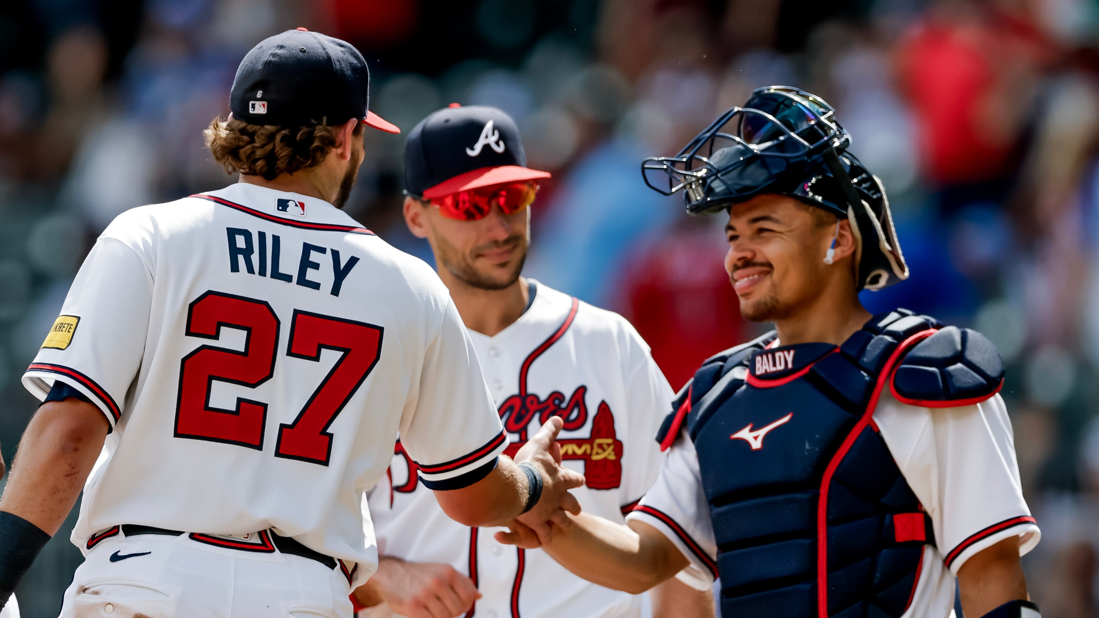 Atlanta Braves third baseman Austin Riley (27) reacts with first baseman Matt Olson, center, and catcher Drake Baldwin, right, after the team defeated the Texas Rangers in a baseball game, Sunday, July 19, 2026, in Atlanta. (AP Photo/Erik S. Lesser)