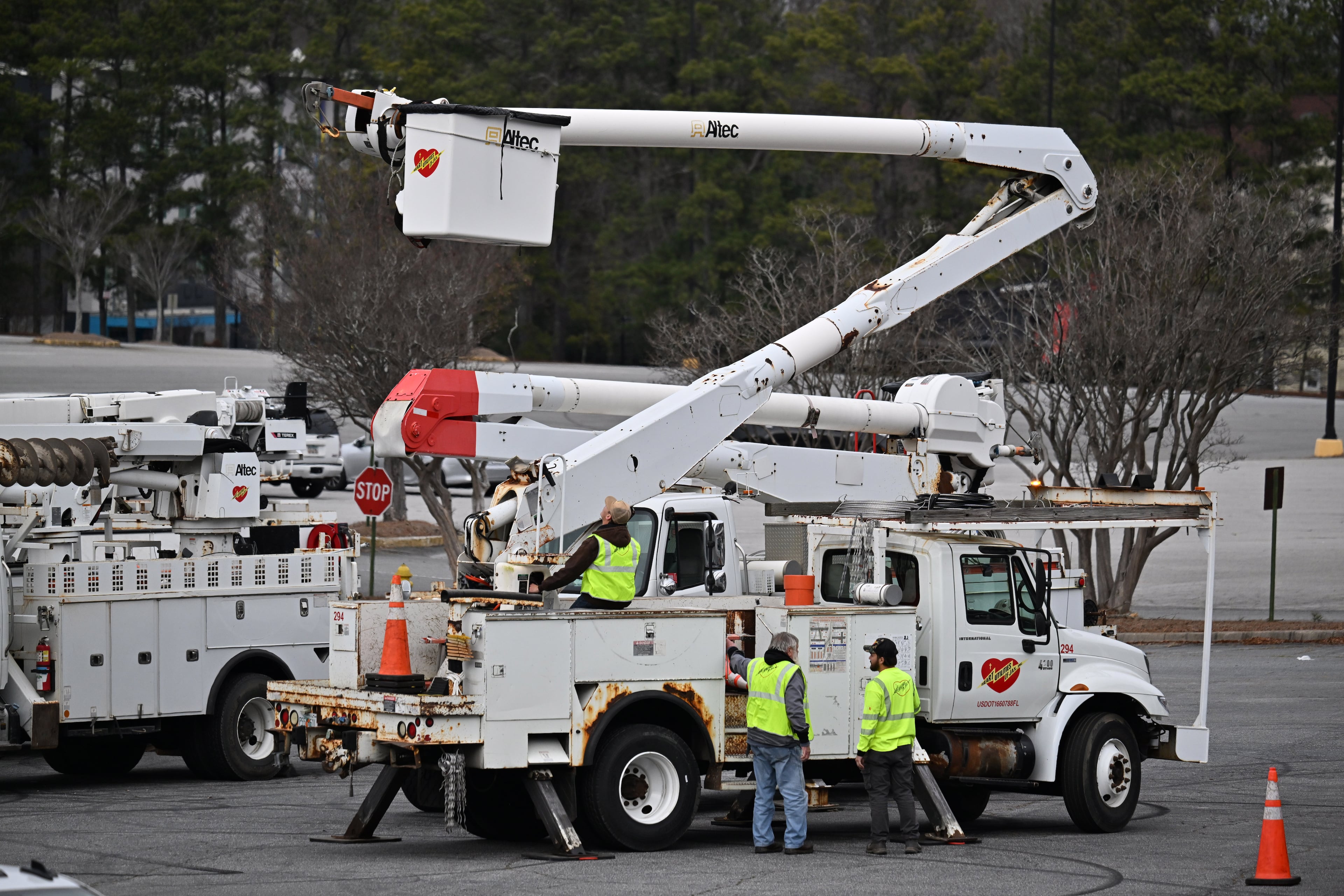 Contractors with Georgia Power stand outside their truck at a parking lot at Northlake Mall, Saturday, Jan. 24, 2026, in Atlanta. (Hyosub Shin/AJC)