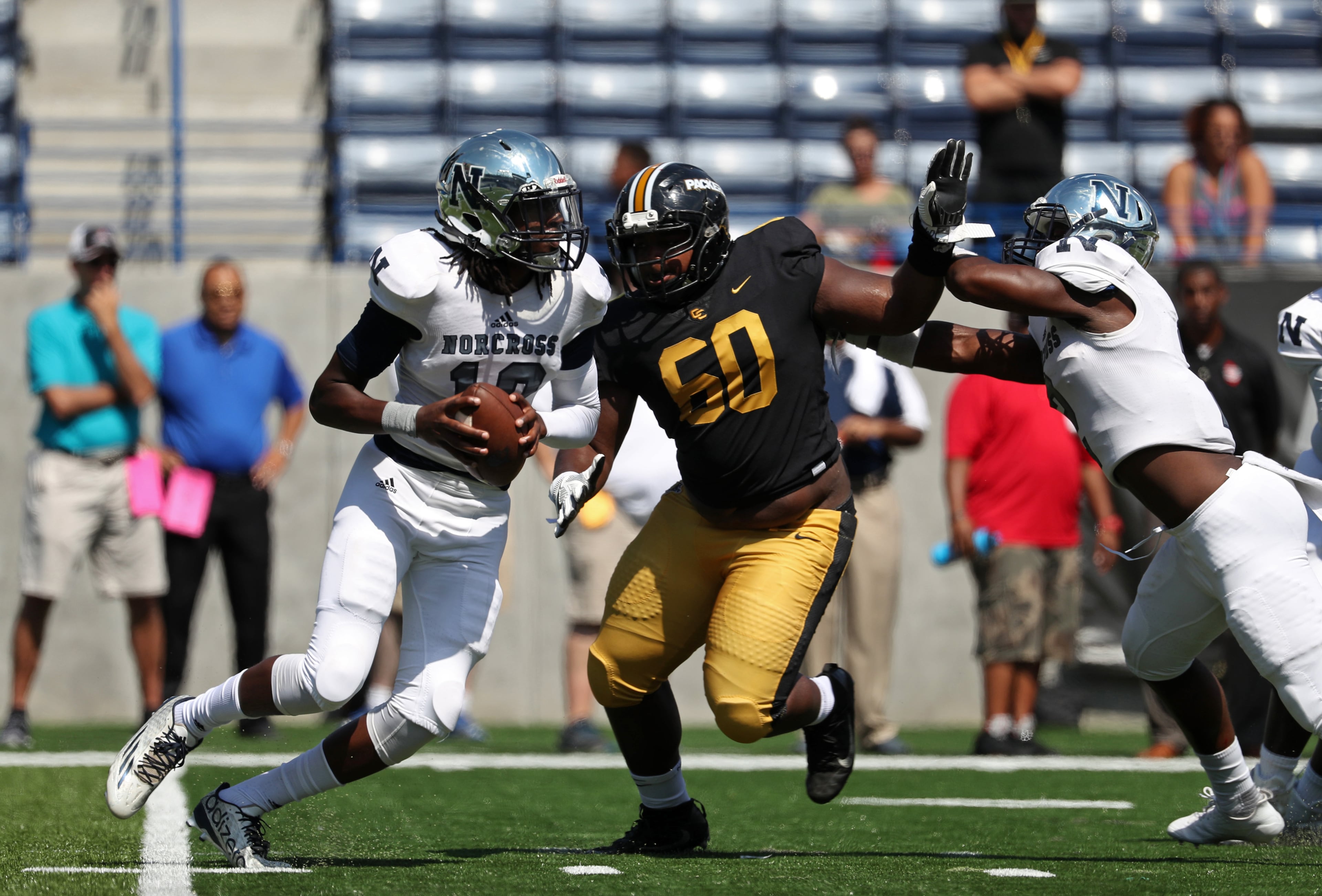 Norcross quarterback Louis Williams (10) eludes the pressure from Colquitt County defensive lineman Brian Merritt (60) in the first half of their game during the Corky Kell Classic at Georgia State Stadium Saturday, August 19, 2017, in Atlanta.