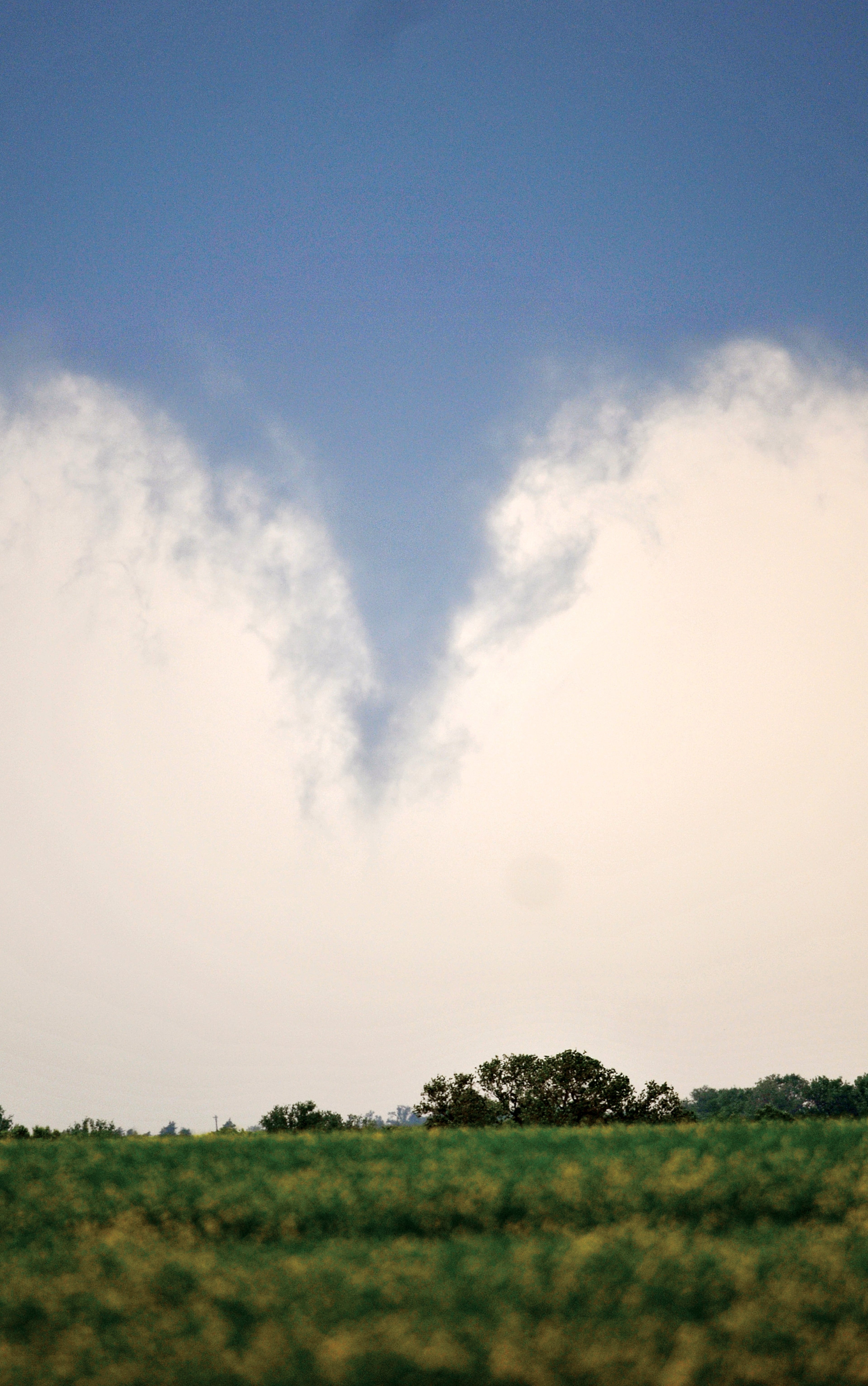 A severe thunderstorm spawns a funnel four miles south of Carrier and north of U.S. 412 northwest of Enid, Okla., on May 6, 2015. A tornado grazed Oklahoma City and its suburbs Wednesday, threatening rush-hour drivers and prompting schools to hold children in safe rooms until the danger passed.