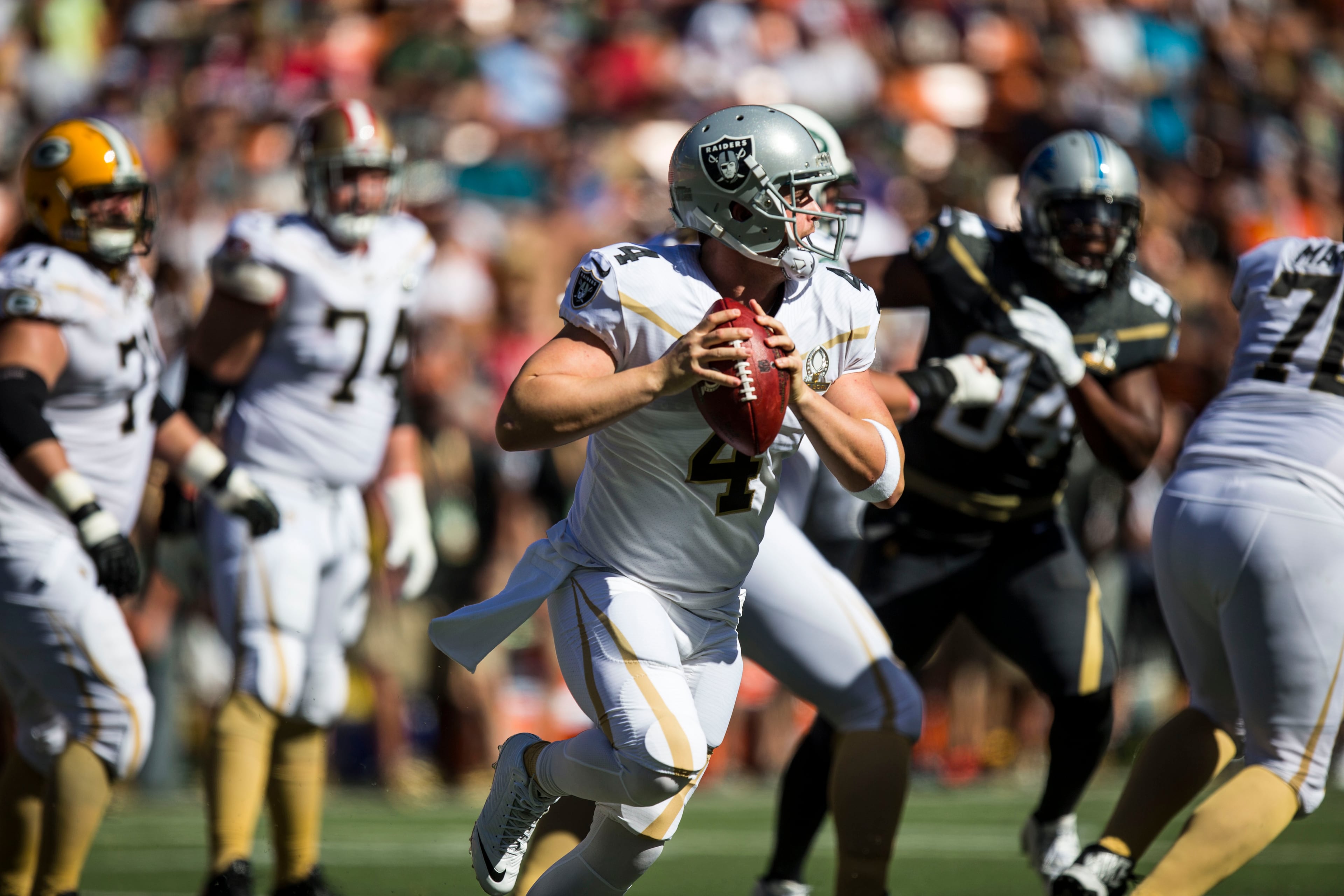 HONOLULU, HI - SUNDAY, JANUARY 31: Team Rice quarterback Derek Carr #4 of the Oakland Raiders scrambles to pass against Team Irvin during the first half of the 2016 Pro Bowl at Aloha Stadium on January 31, 2016 in Honolulu, Hawaii. (Photo by Kent Nishimura/Getty Images)