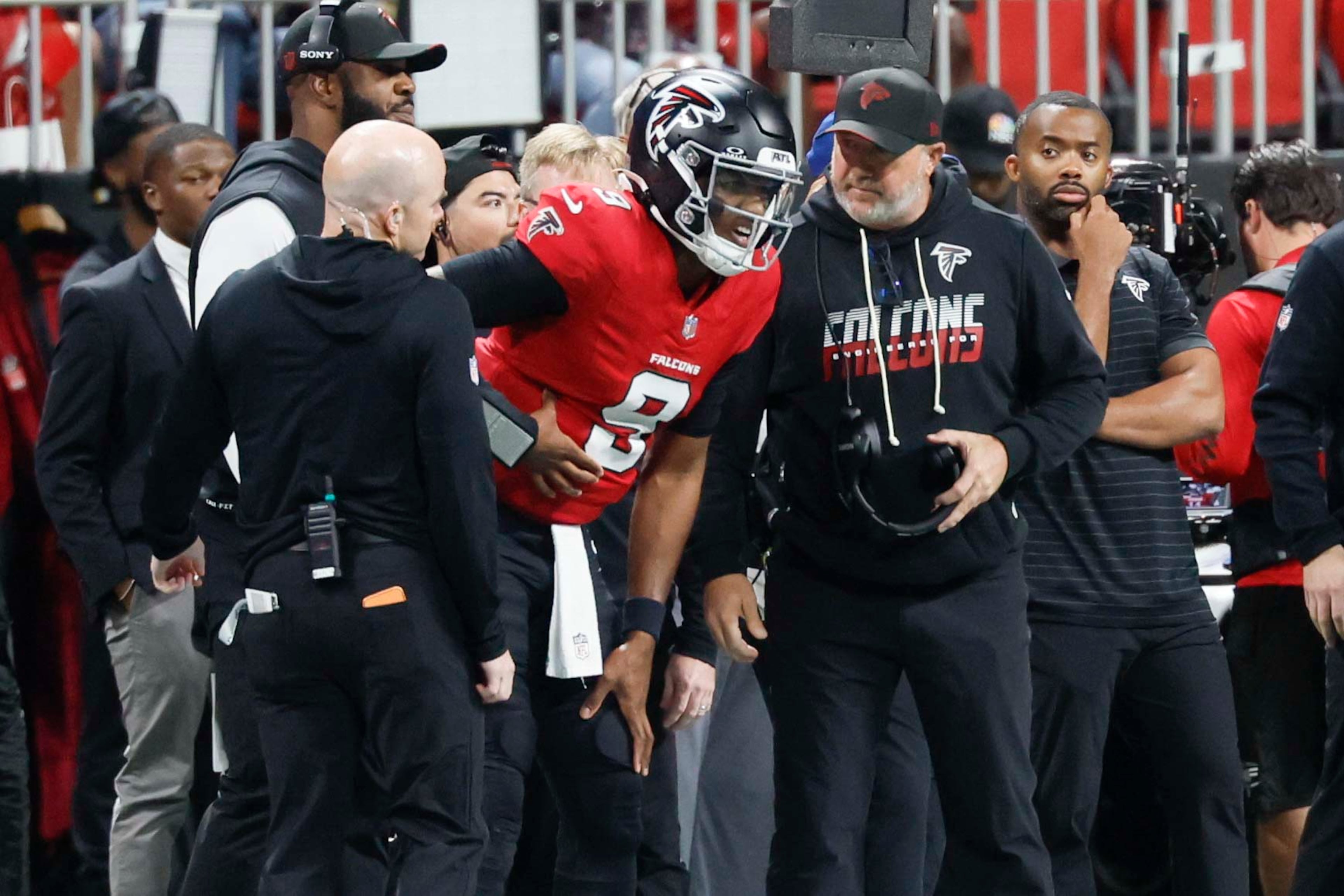 Quarterback Michael Penix Jr. (center) in visible pain on the sideline during the waning minutes of the Falcons' loss to Baltimore. (Miguel Martinez/AJC)