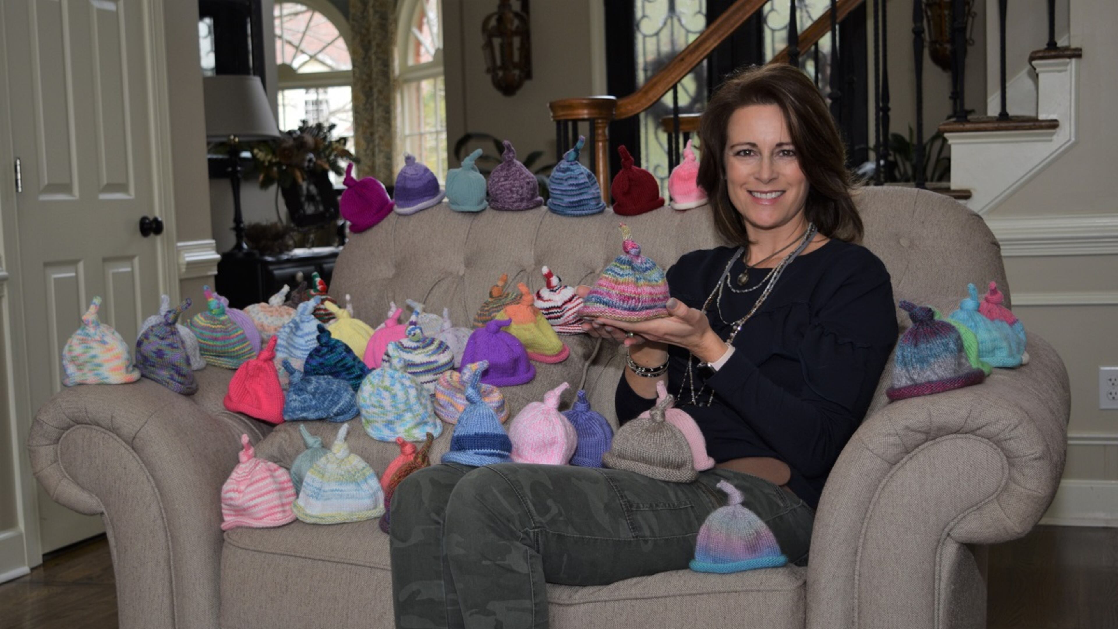 Surrounded by the 52 preemie baby caps that she knitted last year for her New Year’s resolution, Amy Scutt follows the example set by the late Ed Mosely of Acworth. Marty Farrell for the AJC