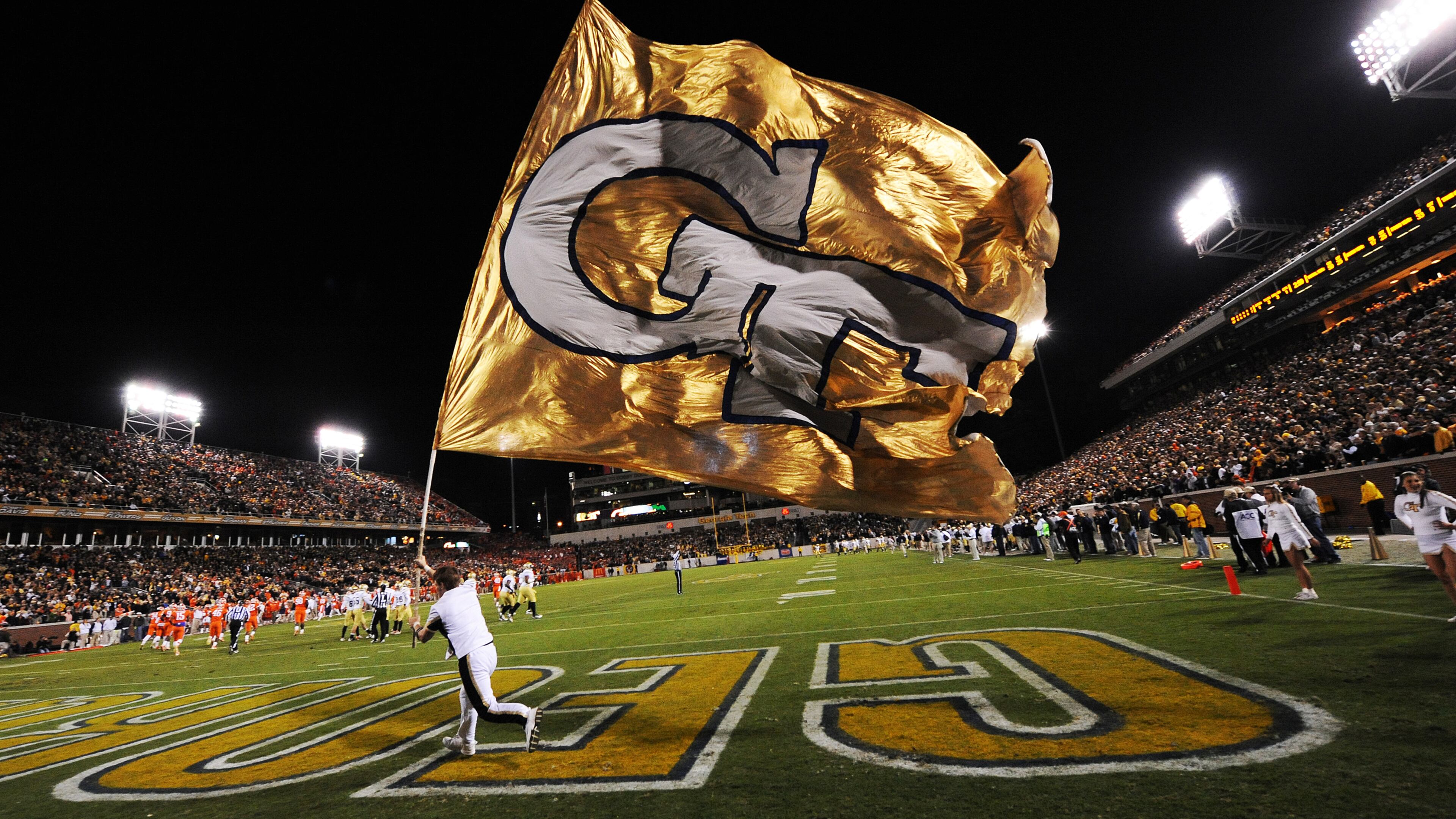A Georgia Tech cheerleader carries a GT flag on the field after Georgia Tech scored a touchdown against Clemson at Georgia Tech on Saturday, Oct 29, 2011. Johnny Crawford / AJC file