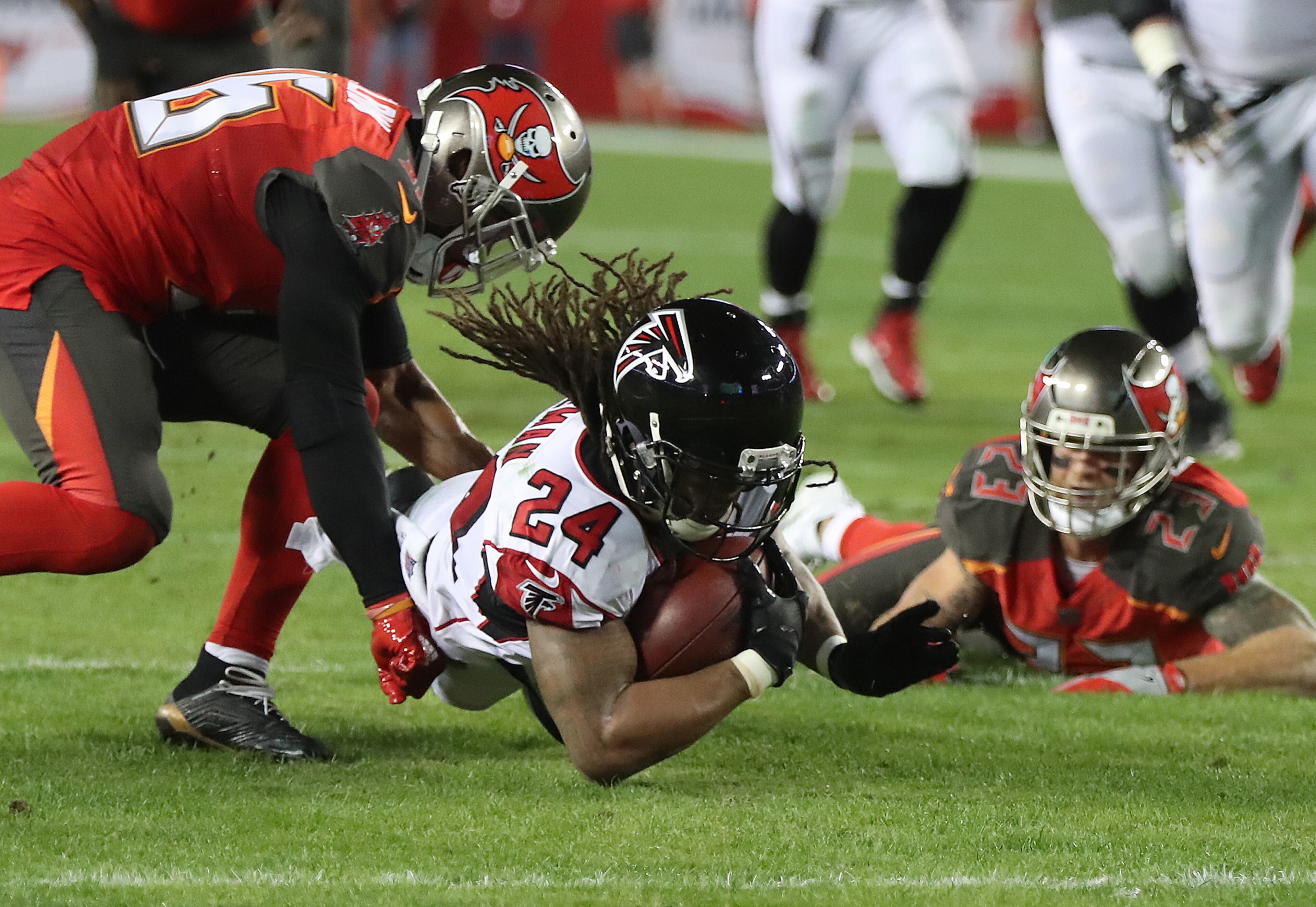 December 18, 2017 Tampa: Falcons running back Devonta Freeman dives for a first down past Buccaneers defender Robert McClain on a scoring drive that ended with a Justin Hardy touchdown catch during the first quarter in a NFL football game on Monday, December 18, 2017, in Tampa. Curtis Compton/ccompton@ajc.com