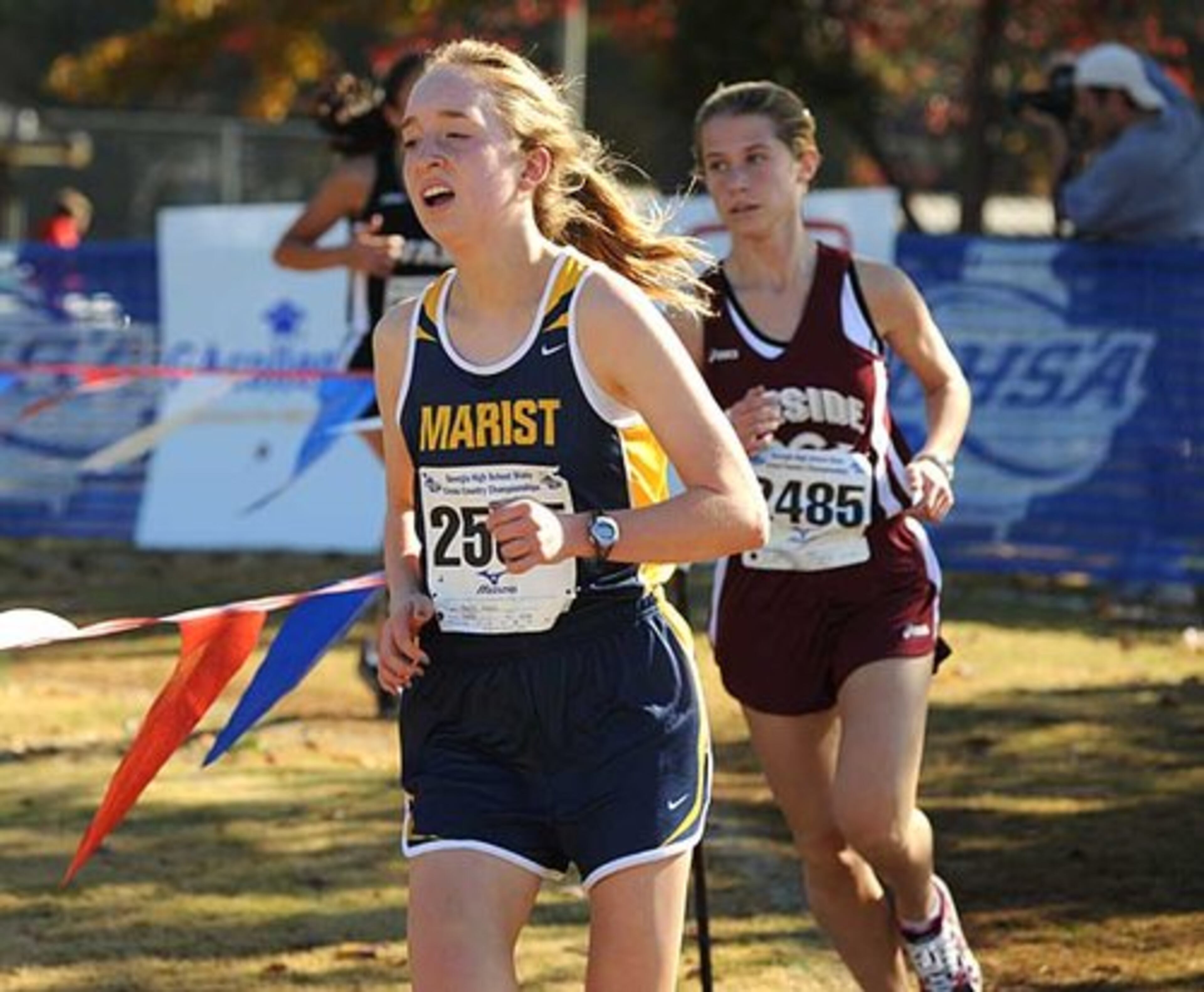 Megan Mauity of Marist and Katie Townsend of Lakeside-Evans race past the halfway point during the girls 4AAAA. Megan's third place finish and time of 19:29.60 was the best for the Marist girls, who went on to take first place in team with a total time of 1:47:07.60.