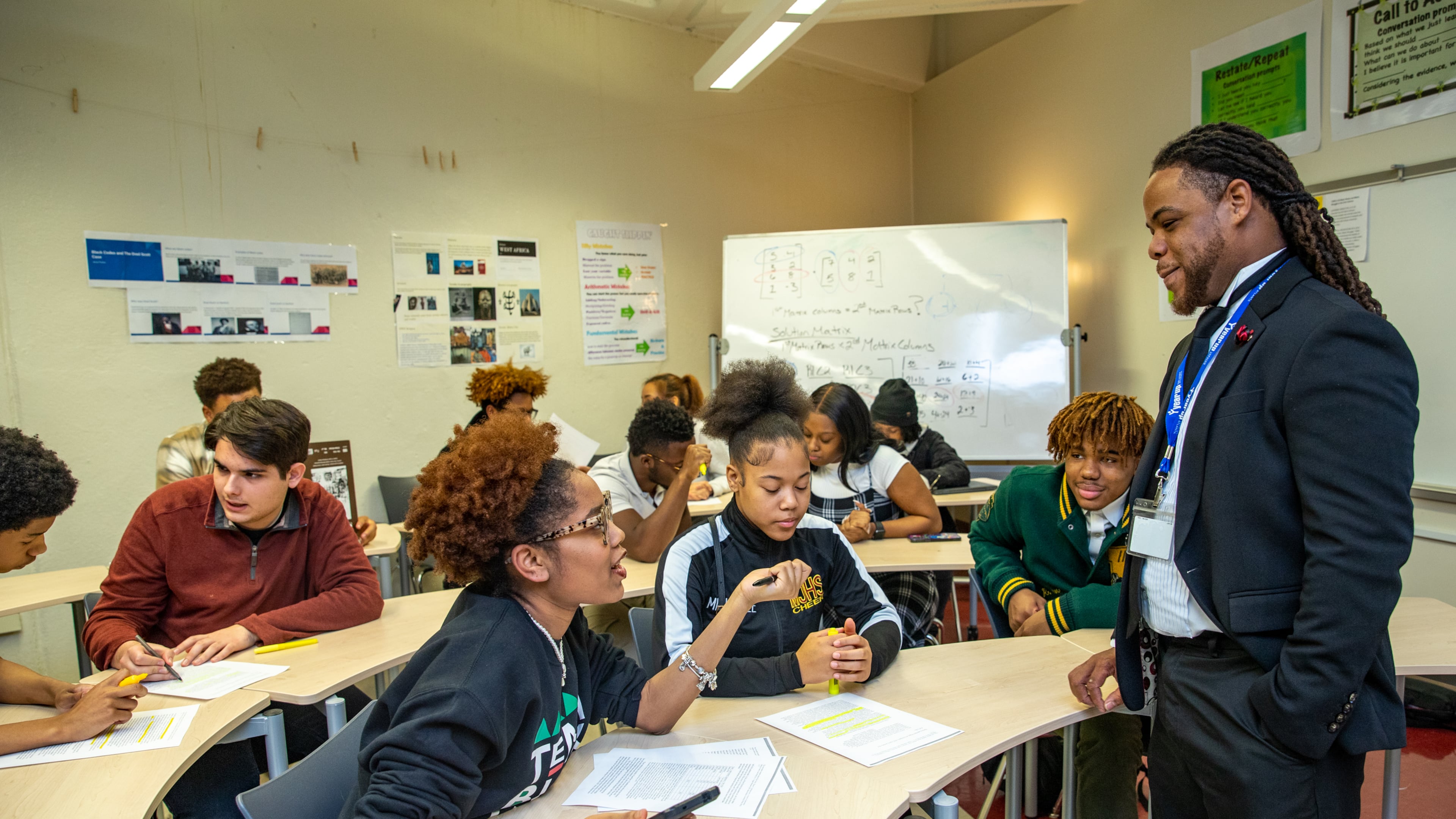Kelsey Allen, front left, talks with her teacher, Rashad Brown, in their Advanced Placement African American Studies at Maynard Jackson High School on Friday, Feb 17, 2023. (Jenni Girtman for The Atlanta Journal-Constitution)