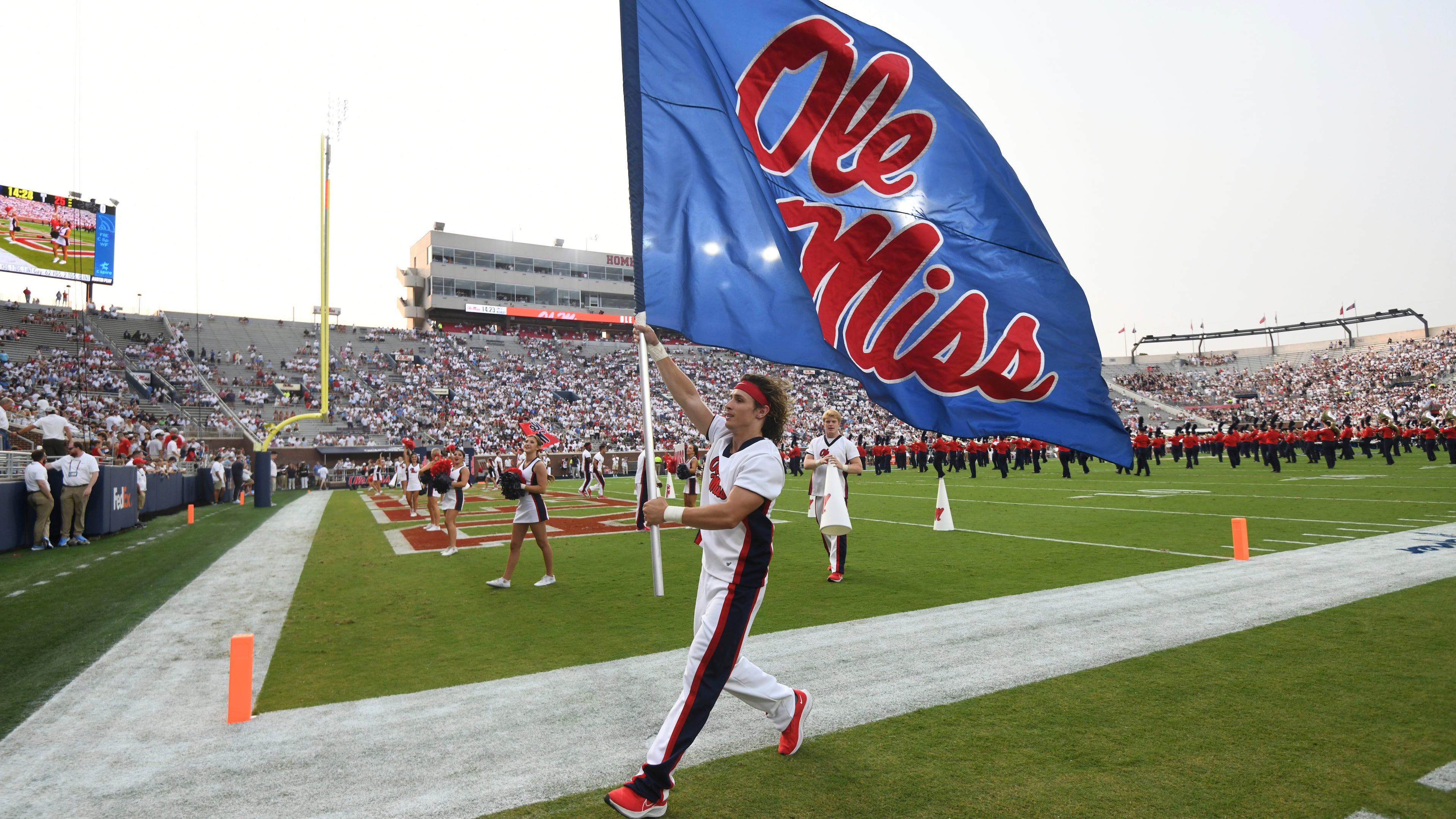 FILE - A cheerleader runs with a flag during an NCAA college football game between Mississippi and Austin Peay at Vaught-Hemingway Stadium in Oxford, Miss., Sept. 11, 2021. (AP Photo/Bruce Newman, File)