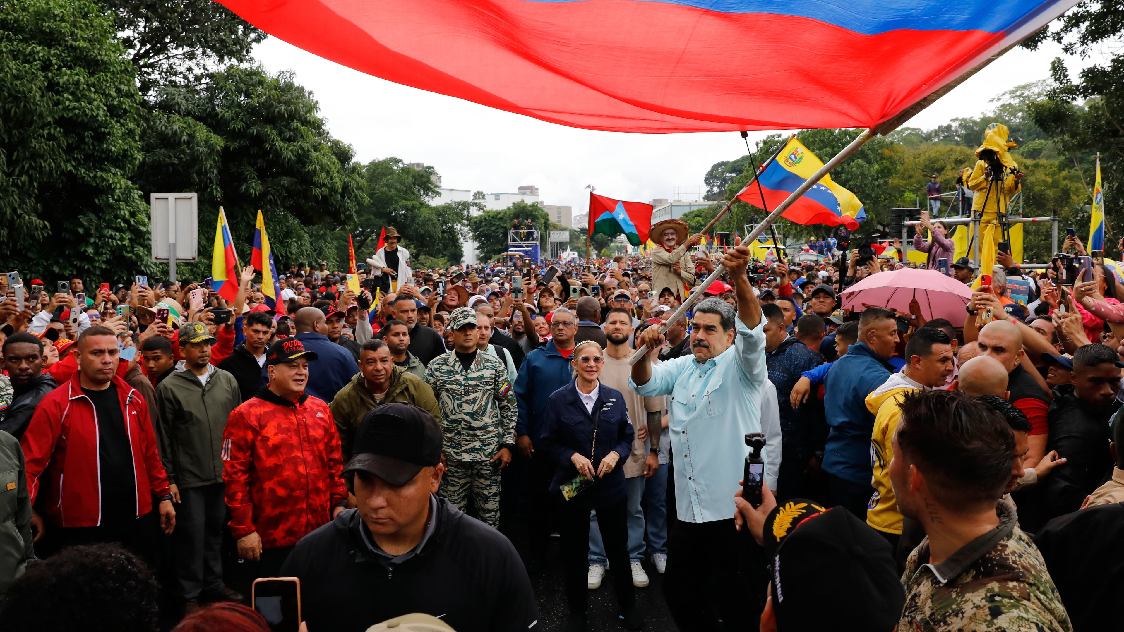 President Nicolas Maduro waves a flag during a rally marking the anniversary of the Battle of Santa Ines, which took place during Venezuela's 19th-century Federal War, in Caracas, Venezuela, Wednesday, Dec. 10, 2025. (AP Photo/Cristian Hernandez)