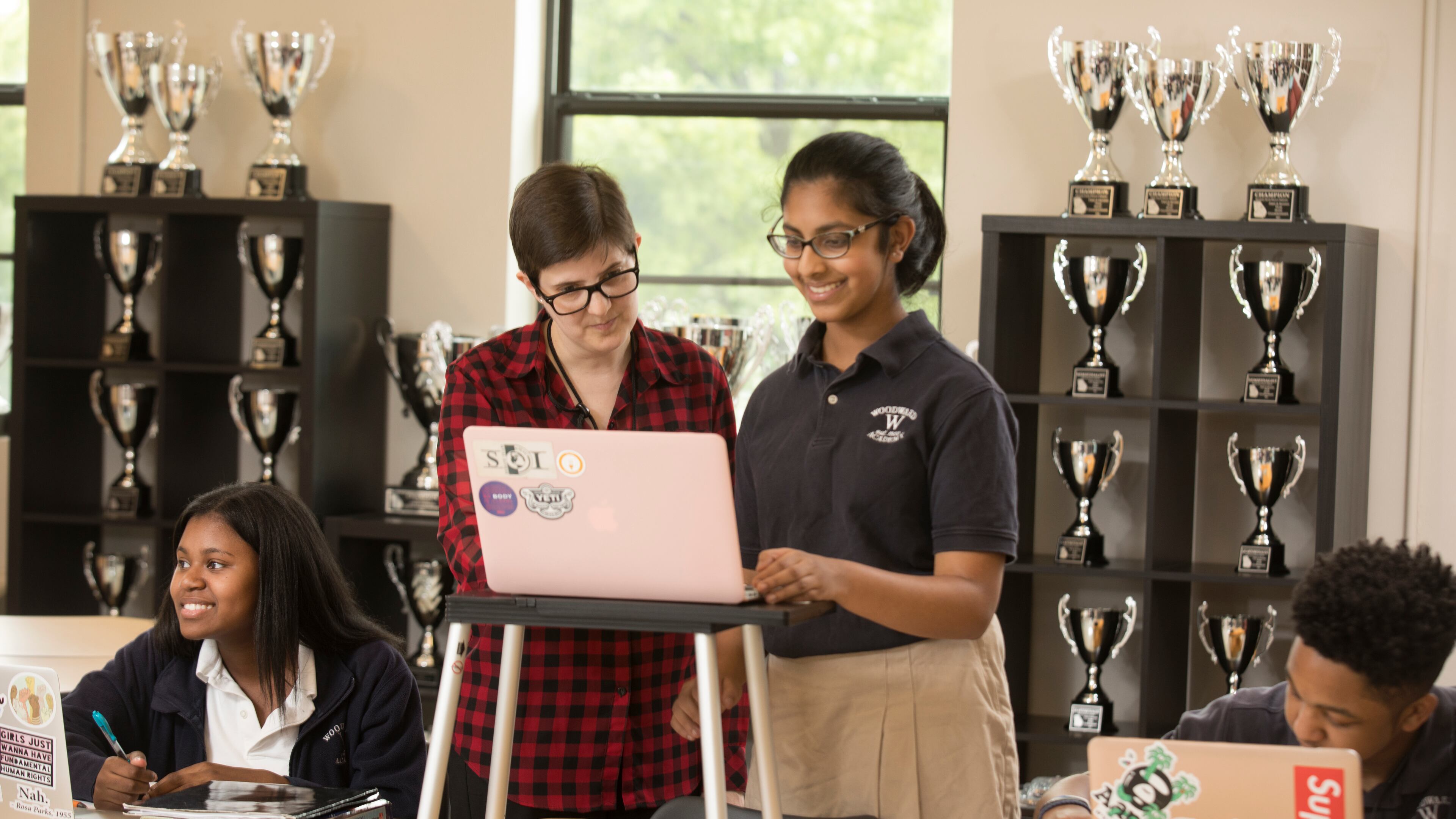 Woodward Academy's Debate Director Maggie Berthiaume (left center) works with senior Sachi Reddy, who took top individual speaker honors at this year's state debate tournament.