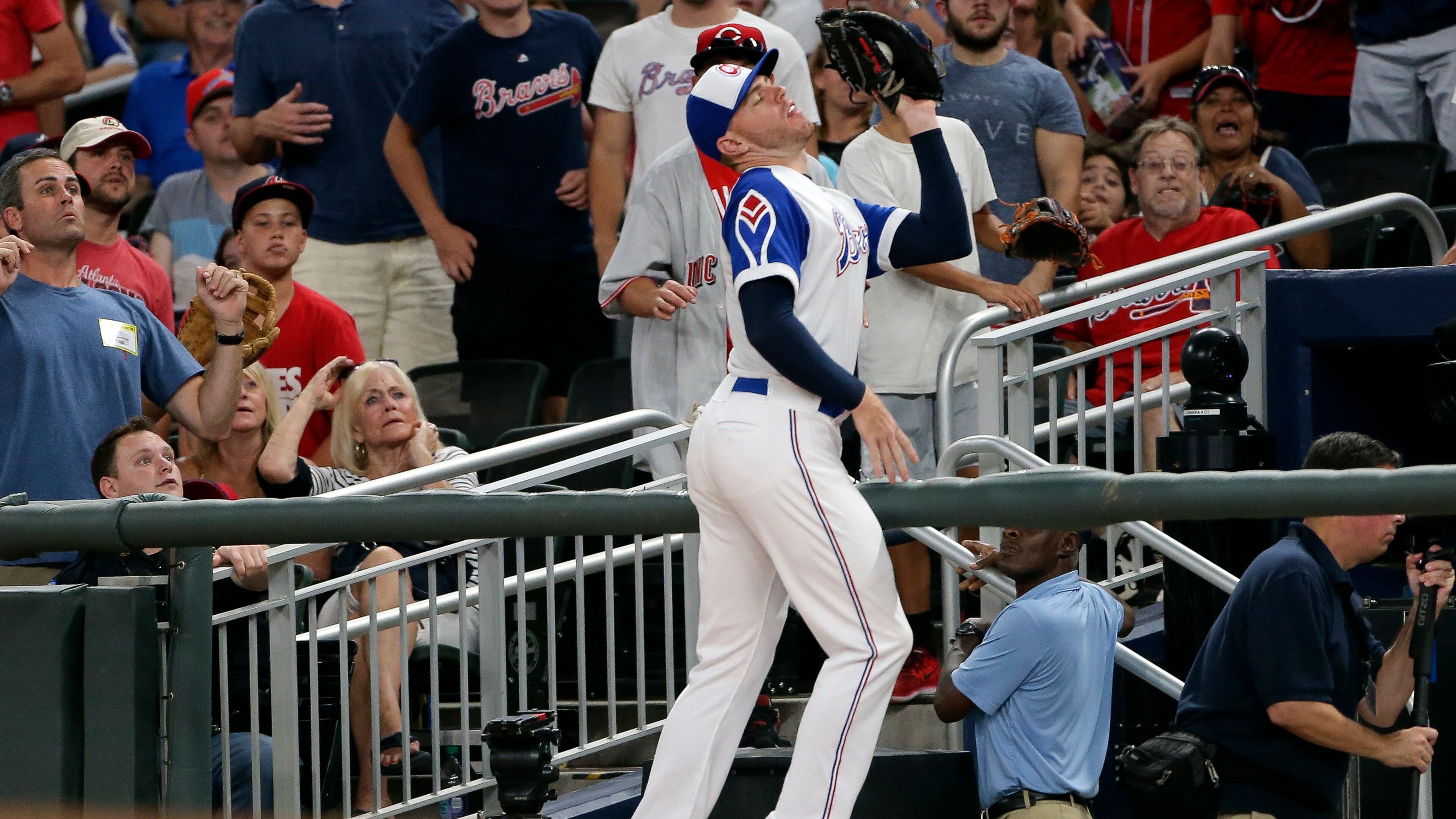 Braves first baseman Freddie Freeman catches a foul ball hit by Reds' Zack Cozart at the railing during the fifth inning of a baseball game Friday, Aug. 18, 2017, in Atlanta. (AP Photo/John Bazemore)