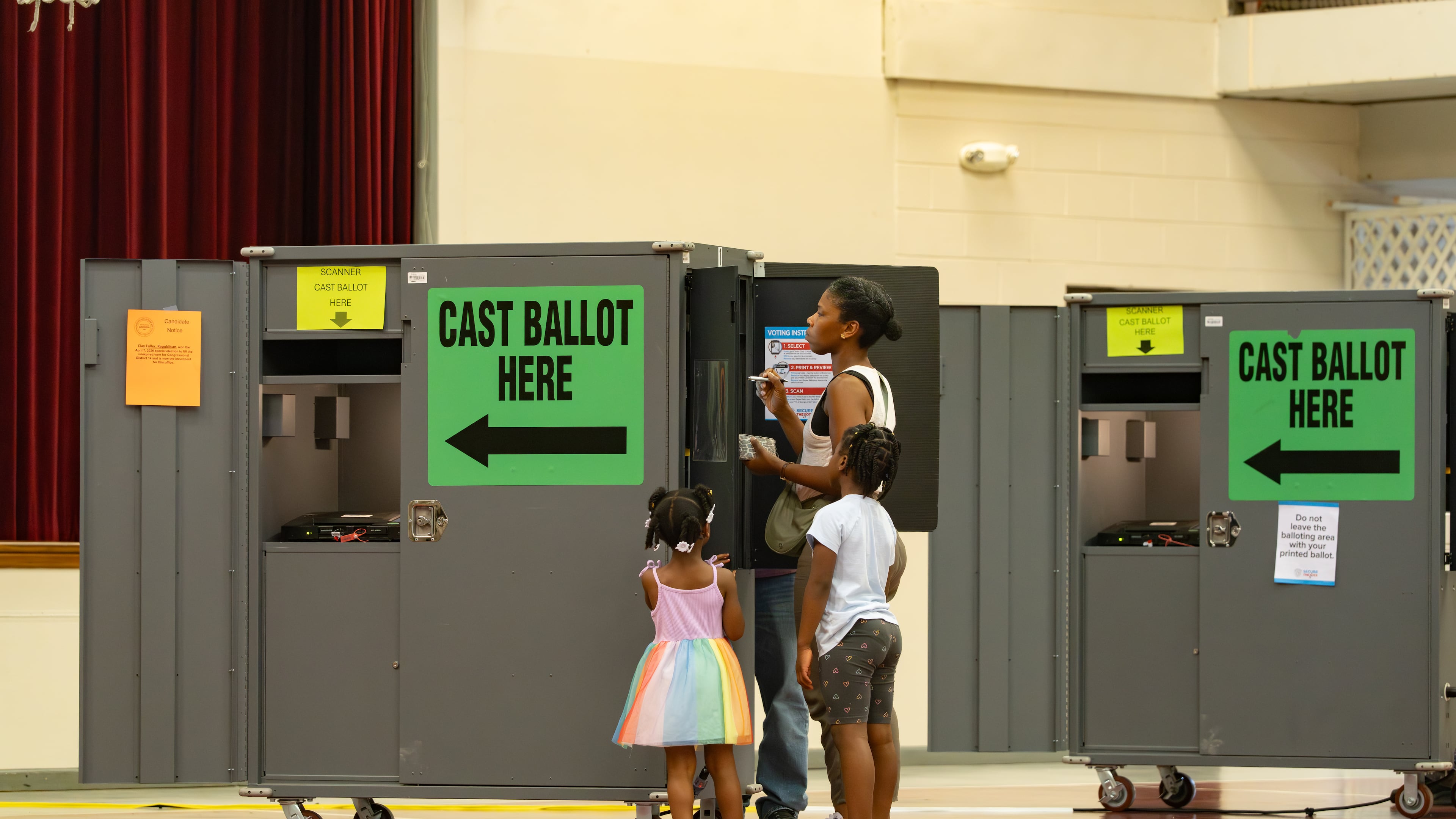 A woman votes while her children watch at the Floyd Road Babtist Church polling location in Austell, Georgia. Tuesday, May 19, 2026 (Ben Hendren for the AJC)
