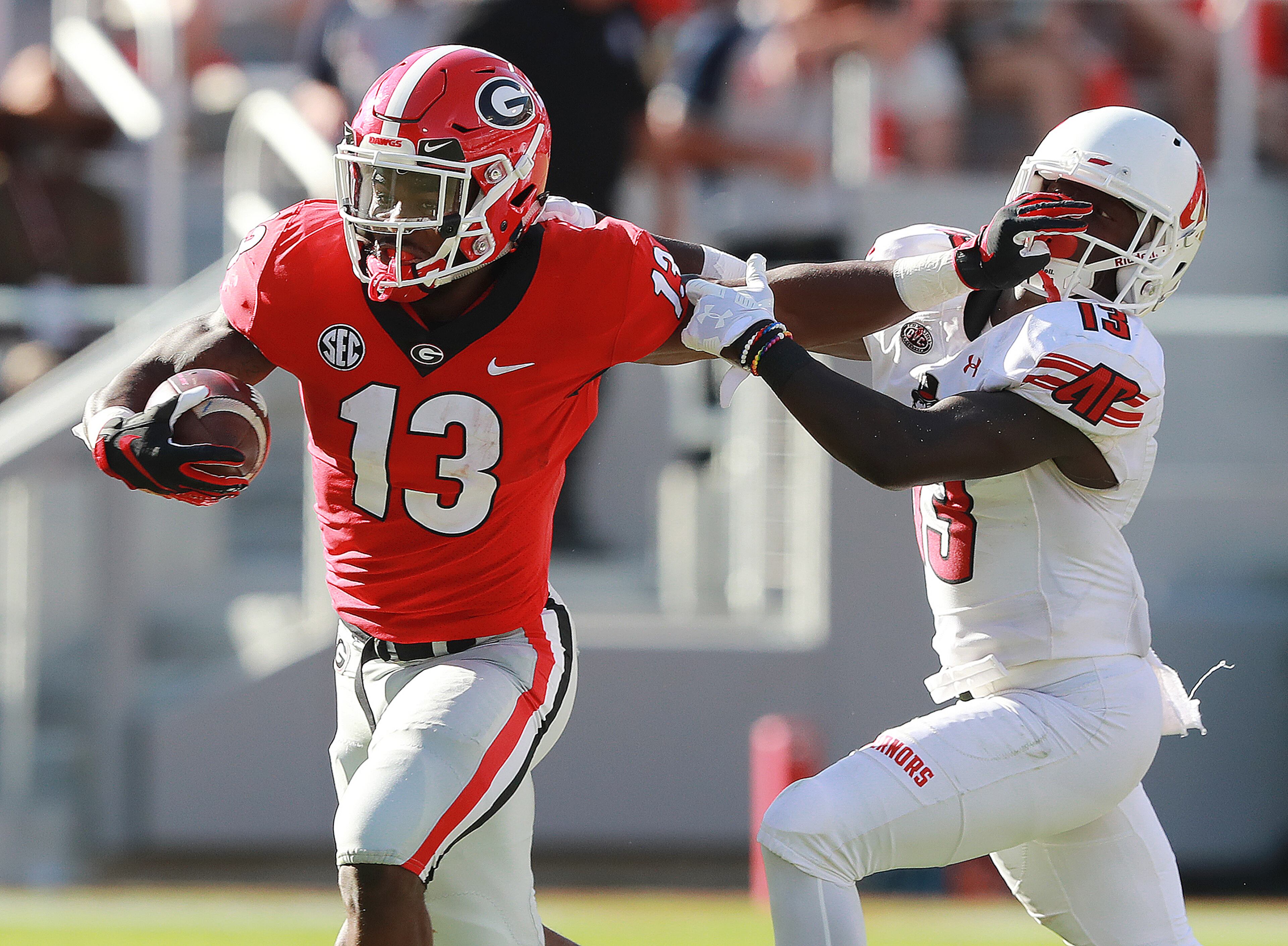 September 1, 2018 Athens: Georgia Bulldogs running back Elijah Holyfield breaks a tackle by Austin Peay defender Kordell Jackson for yardage during the second half in a NCAA college football game on Saturday, Sept 1, 2018, in Athens. Curtis Compton/ccompton@ajc.com