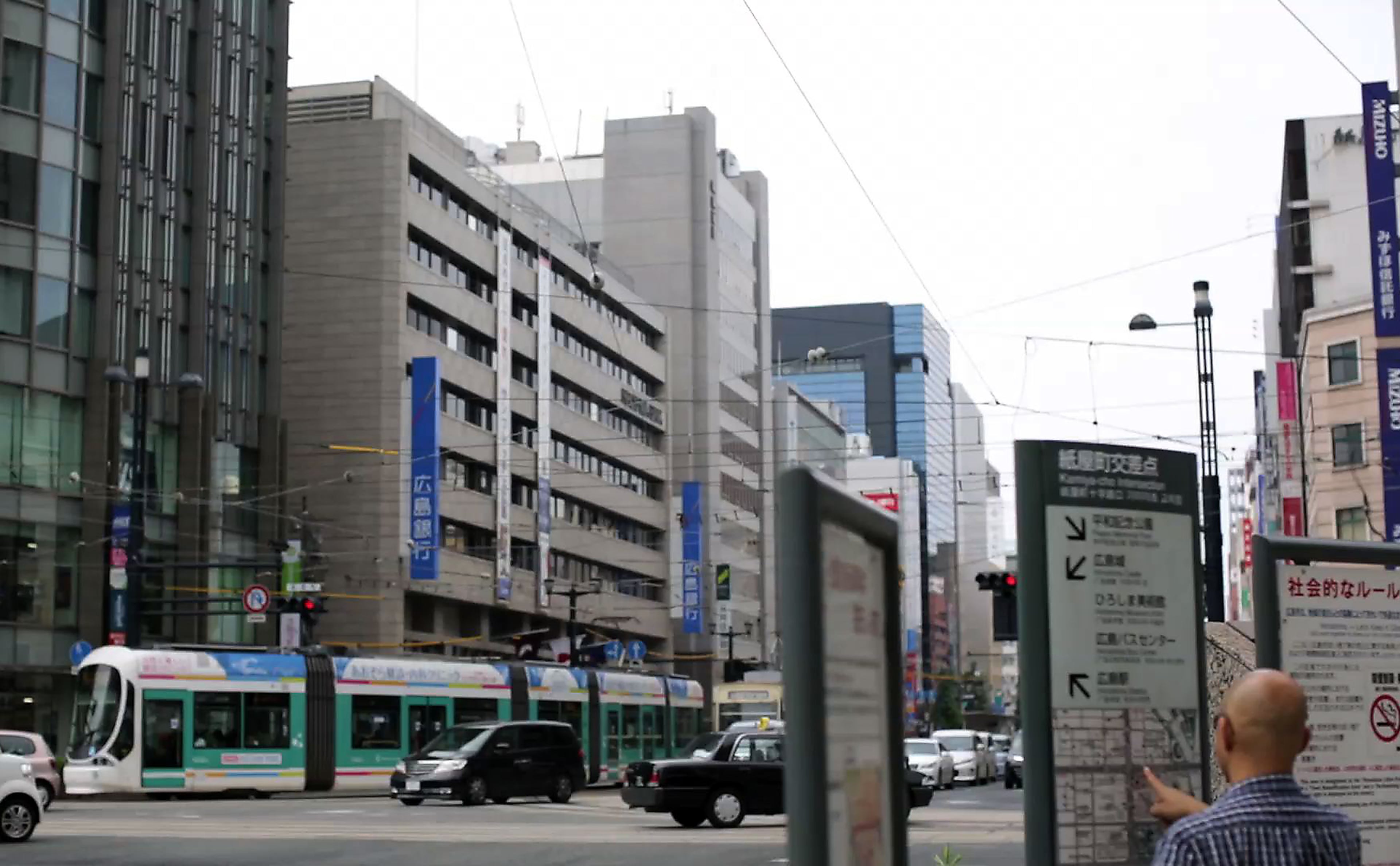 In this July 5, 2015 photo, a man checks with a public street map at a crossroad near now known as Atomic Bomb Dome in Hiroshima, western Japan. On Aug. 6, 1945, a U.S. plane dropped an atomic bomb on Hiroshima, the first nuclear weapon has been used in war. Japan surrendered on Aug. 15, ending World War II. (AP Photo/Eugene Hoshiko)