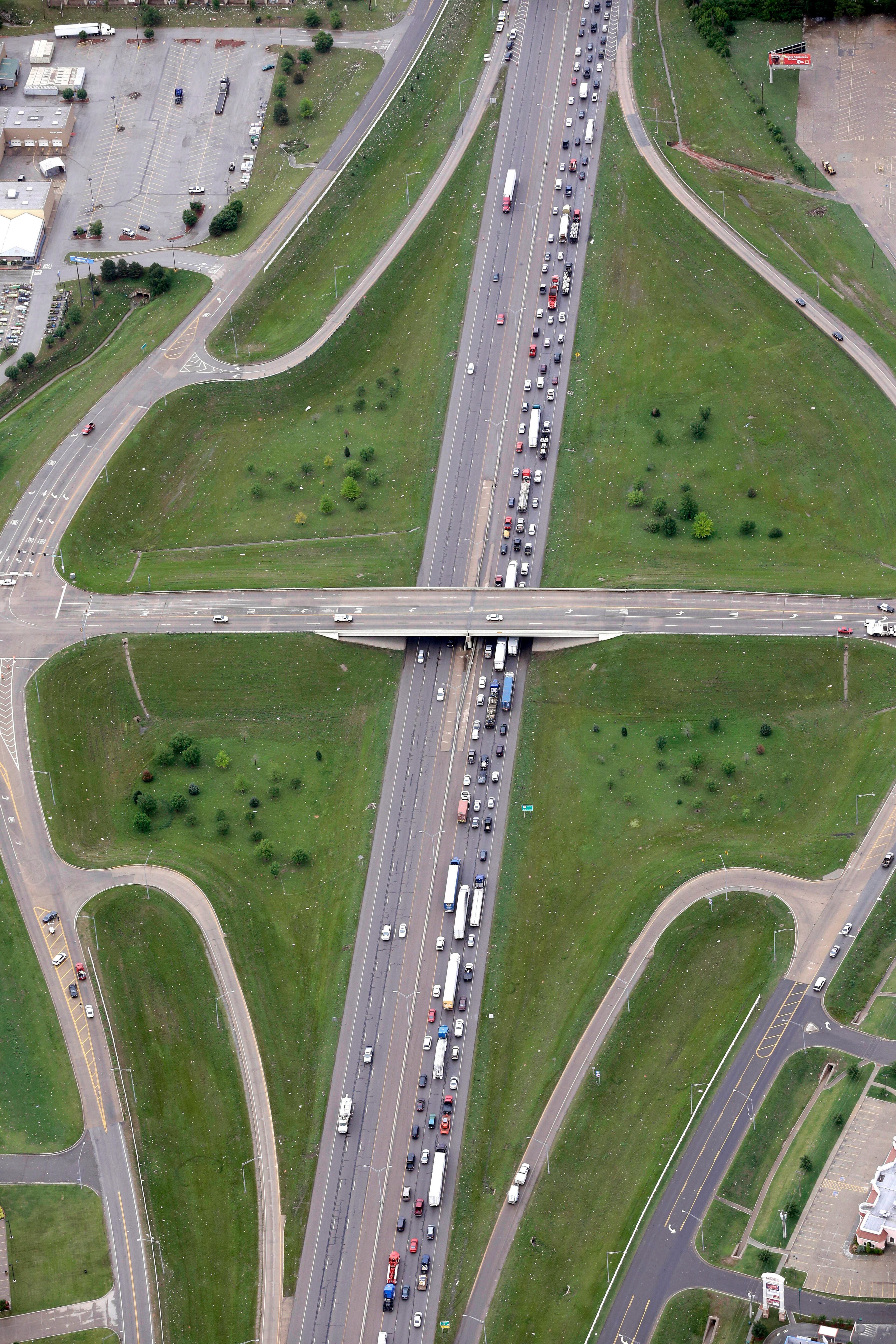 In this Tuesday, May 21, 2013 aerial photo traffic moves slowly along the northbound lanes of Interstate 35 as it runs through the city of Moore, Okla., which was hit by Monday's powerful tornado. The huge tornado roared through the Oklahoma City suburb Monday, flattening entire neighborhoods and destroying an elementary school with a direct blow as children and teachers huddled against winds. (AP Photo/Tony Gutierrez)