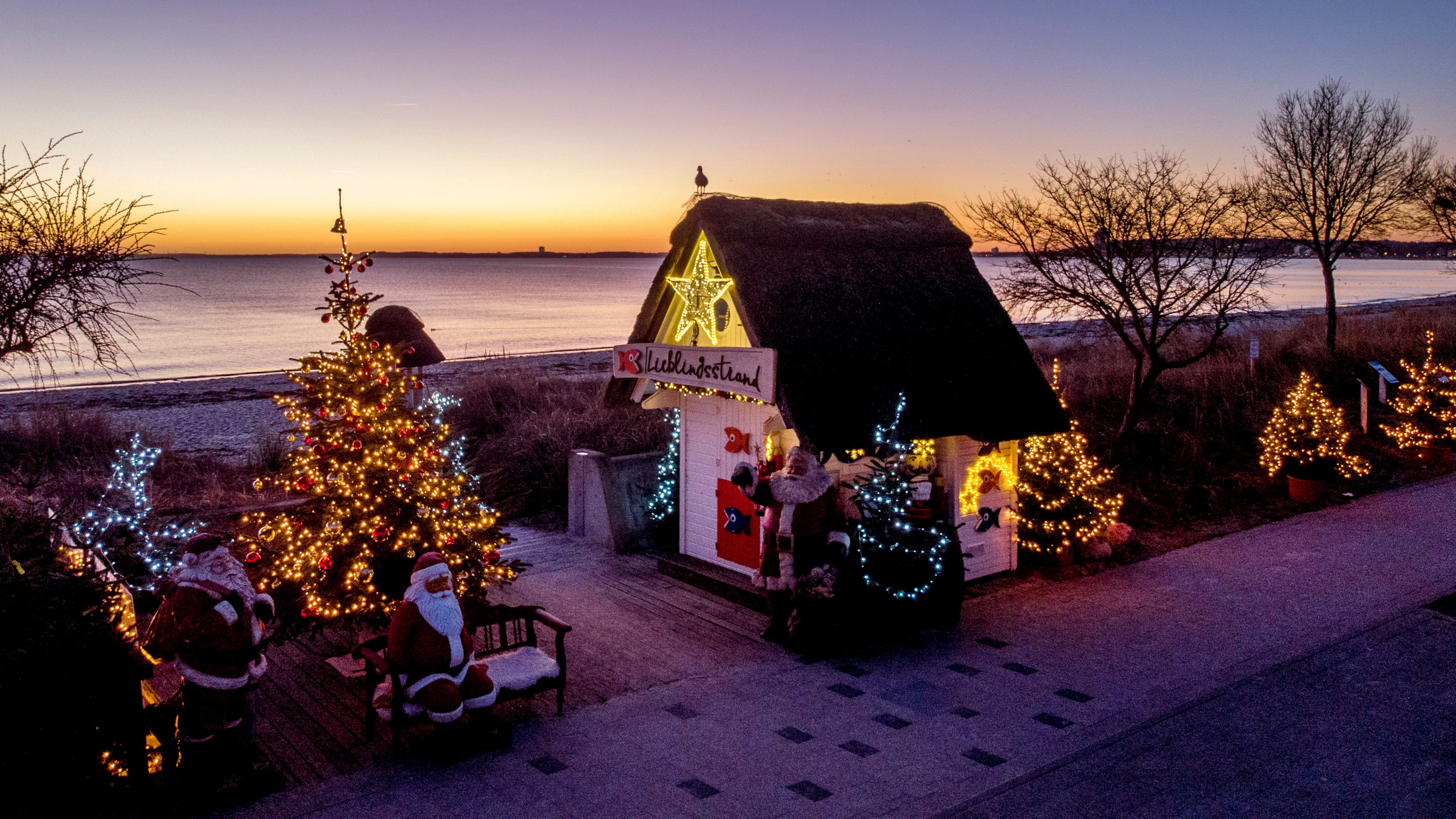 FILE - Christmas trees and Santa Clauses decorate the entrance to the beach in Haffkrug, northern Germany, Monday, Dec. 20, 2021. (Photo/Michael Probst, File)