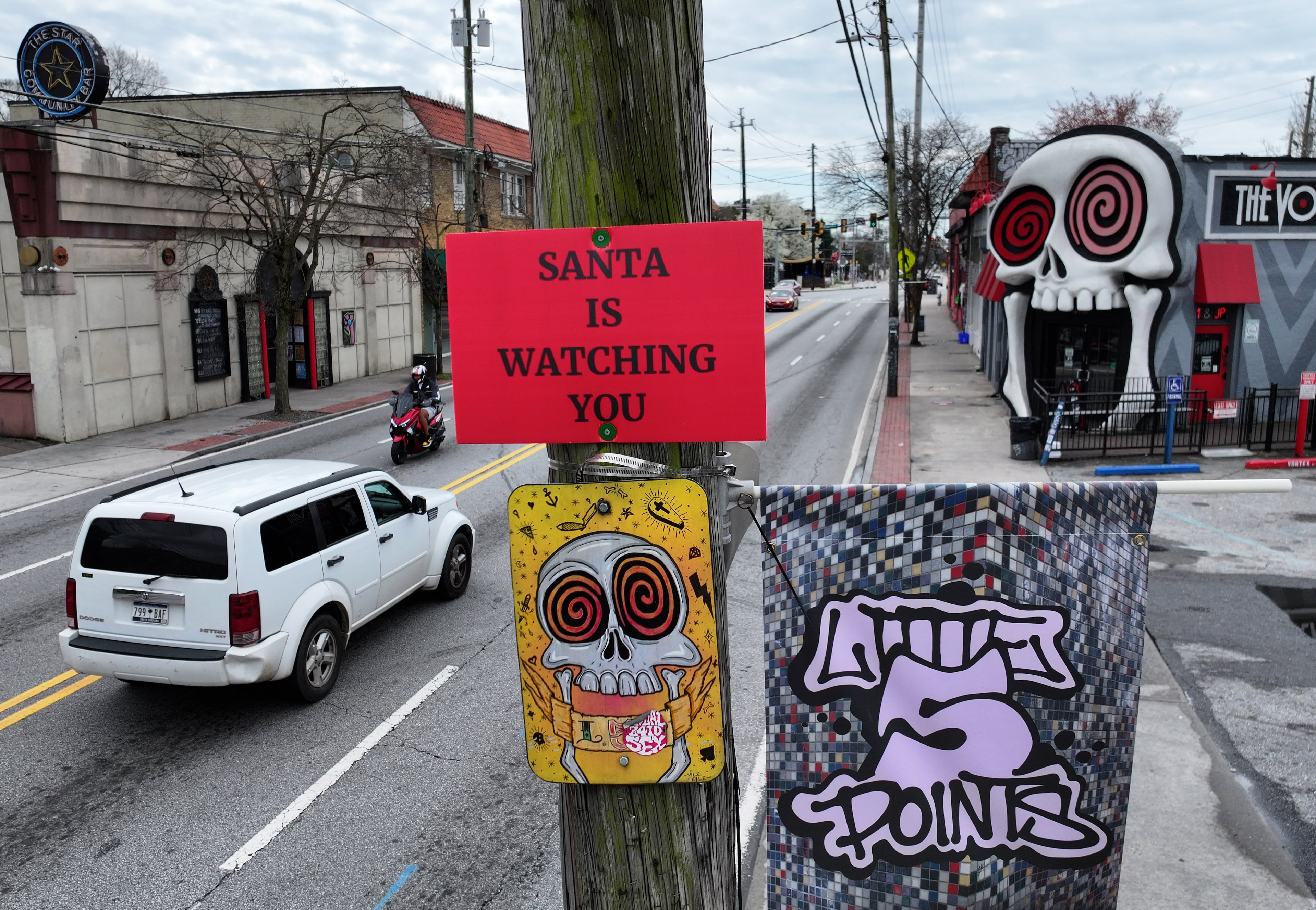 ‘SANTA IS WATCHING YOU’ sign is seen on utility pole on Moreland Avenue near the Vortex Bar and Grill on March 10. Mysterious signs started appearing high on utility poles around the east side of Atlanta. (Hyosub Shin/AJC)