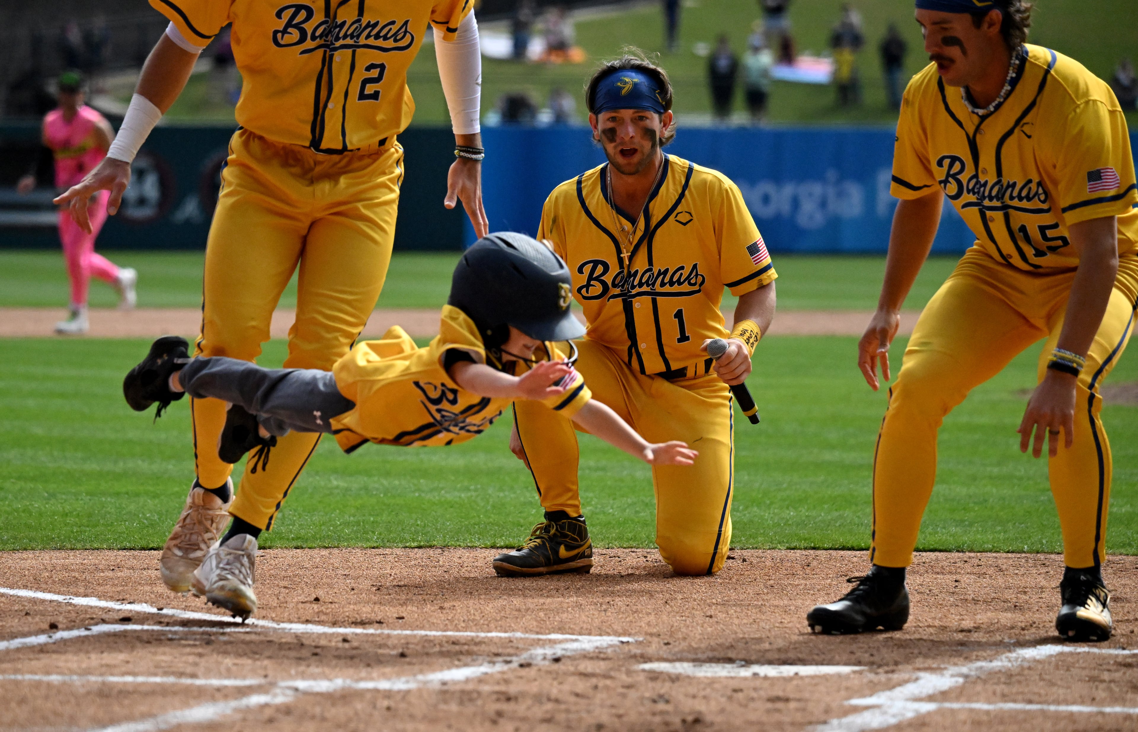 An young Savannah Bananas fan soars through the air while scoring a run during pre-game fun at Coolray Field, Saturday in Lawrenceville. (Hyosub Shin / Hyosub.Shin@ajc.com)