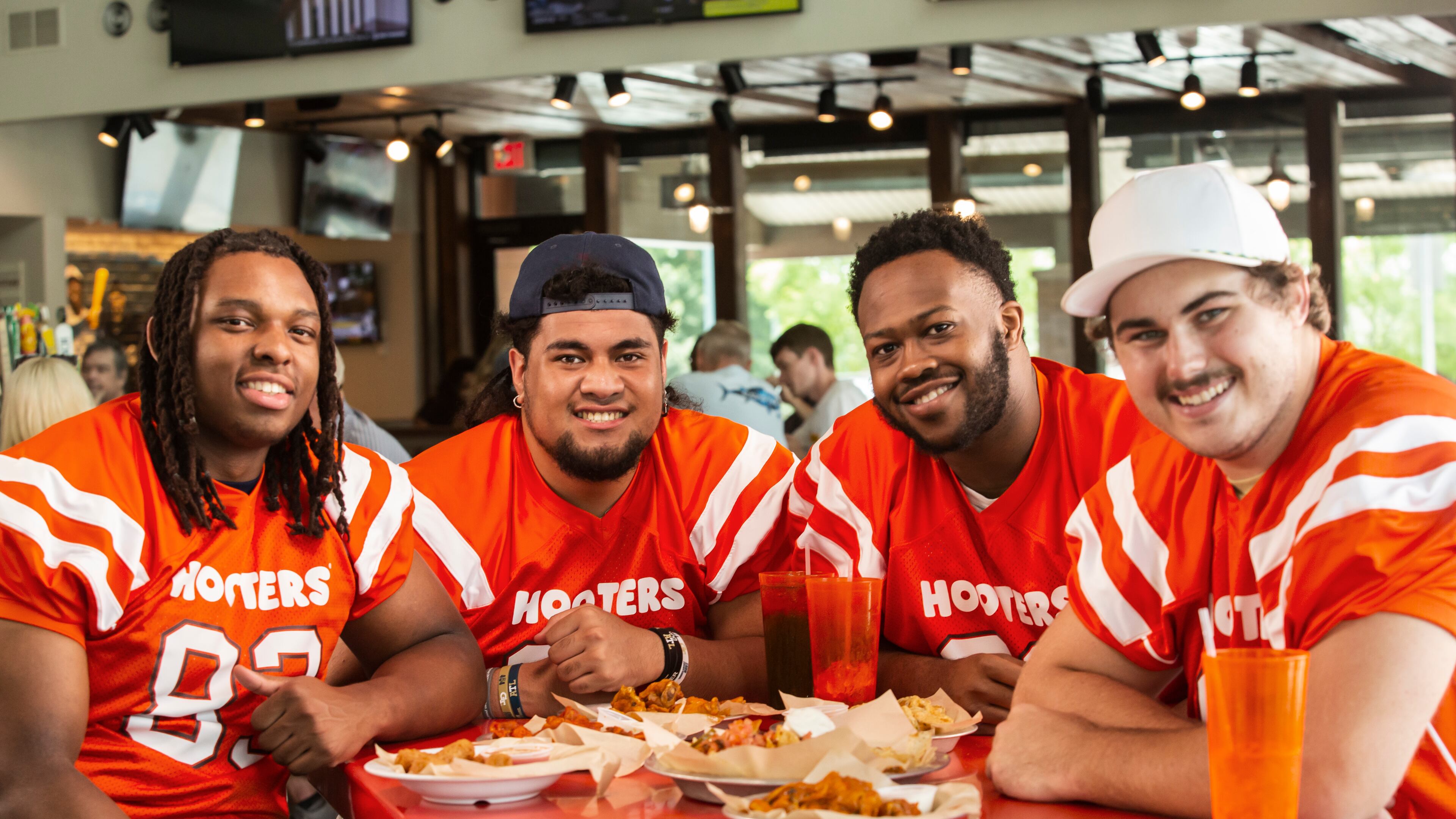 Georgia Tech offensive linemen (from left) Jordan Williams, Paula Vaipulu, Paul Tchio and Pierce Quick pose for a publicity photo for Hooters, which all four (plus three teammates) will represent in an NIL deal announced Monday. (Photo provided by Hooters of America)