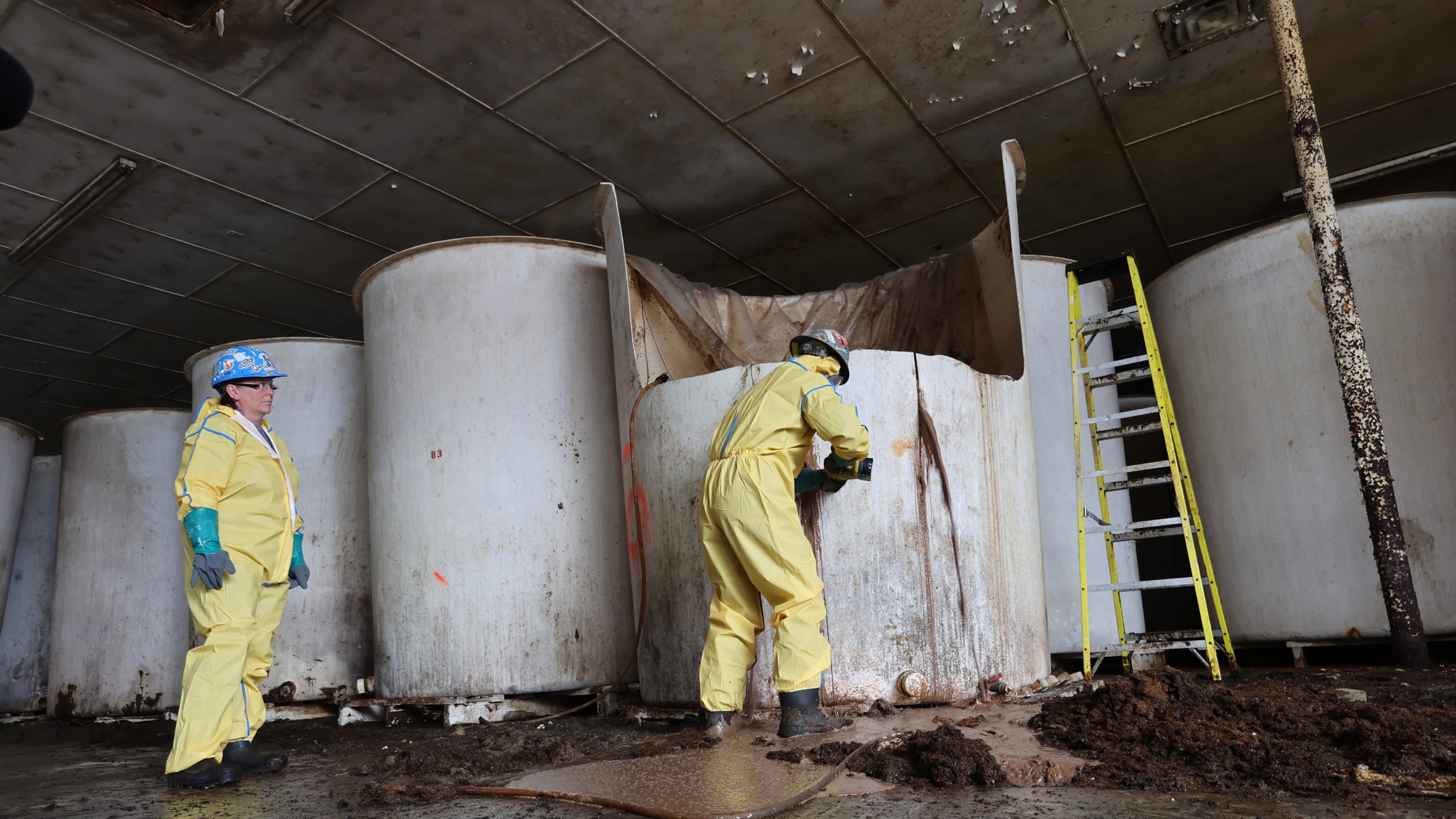 Sludge pours out of a vat of fermenting fish sauce in an abandoned fish sauce factory in St. Mary's, N.L., on Tuesday July 28, 2026. (Elling Lien/The Canadian Press via AP)